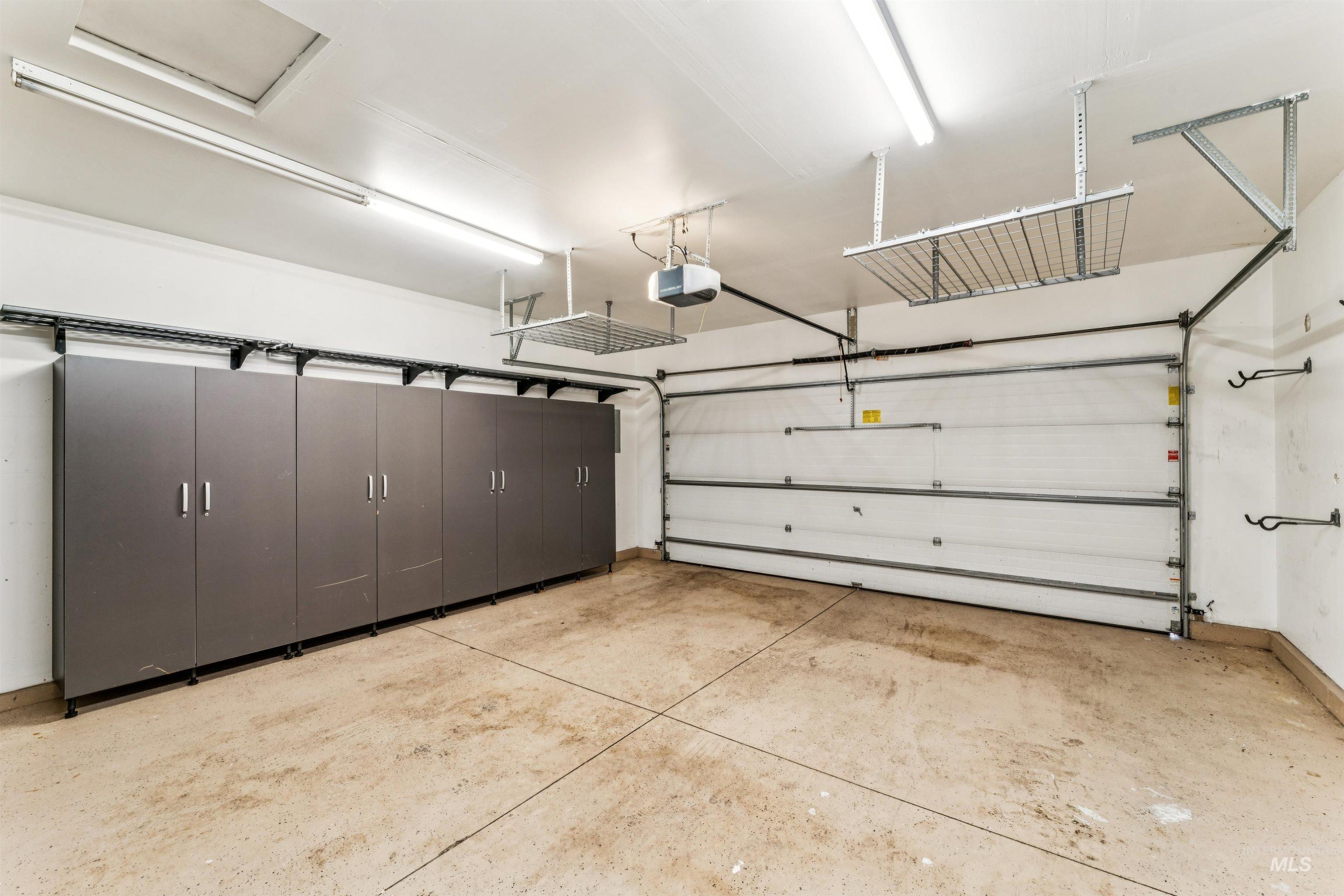Garage featuring baseboards and a garage door opener