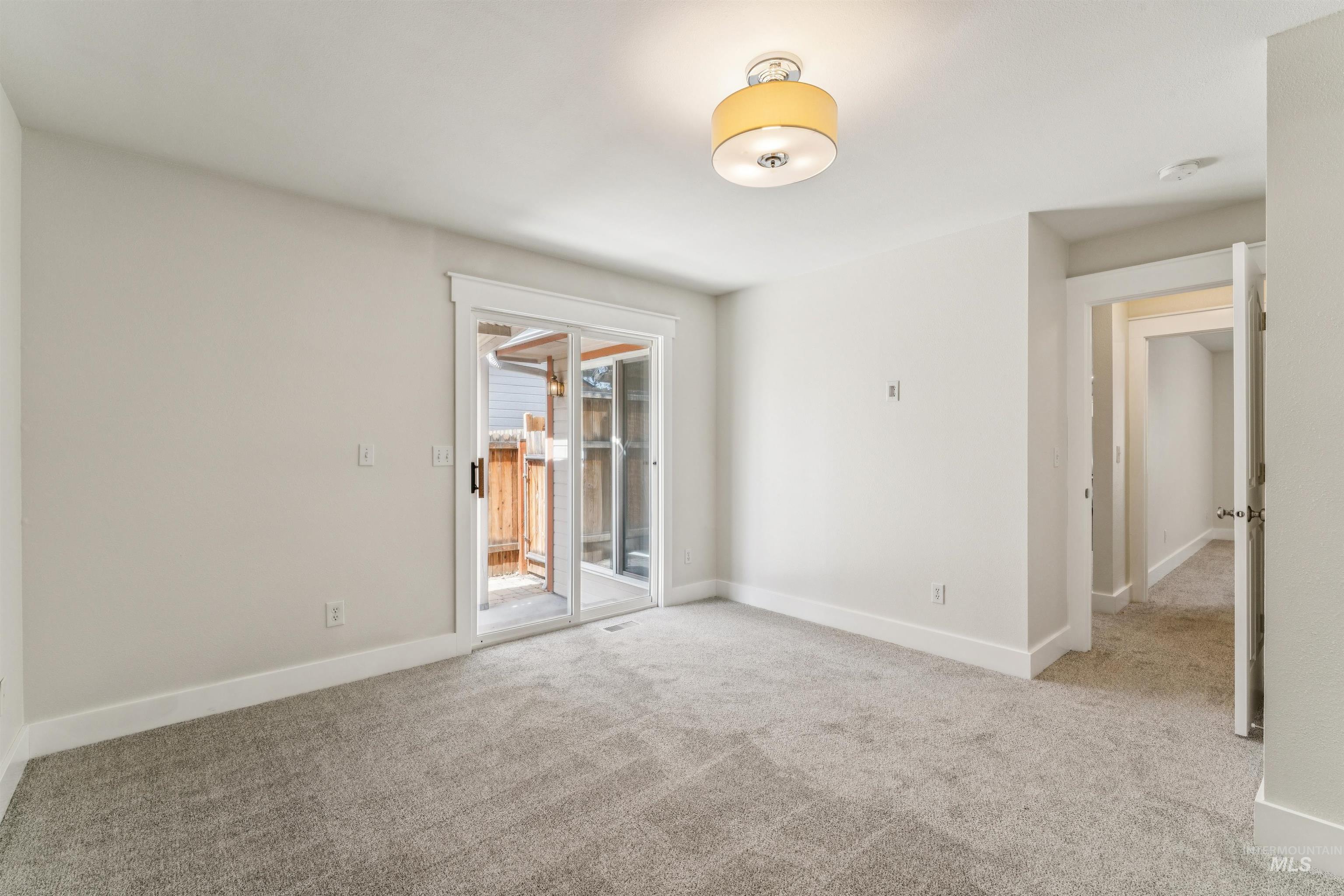 Unfurnished room with light carpet and baseboards