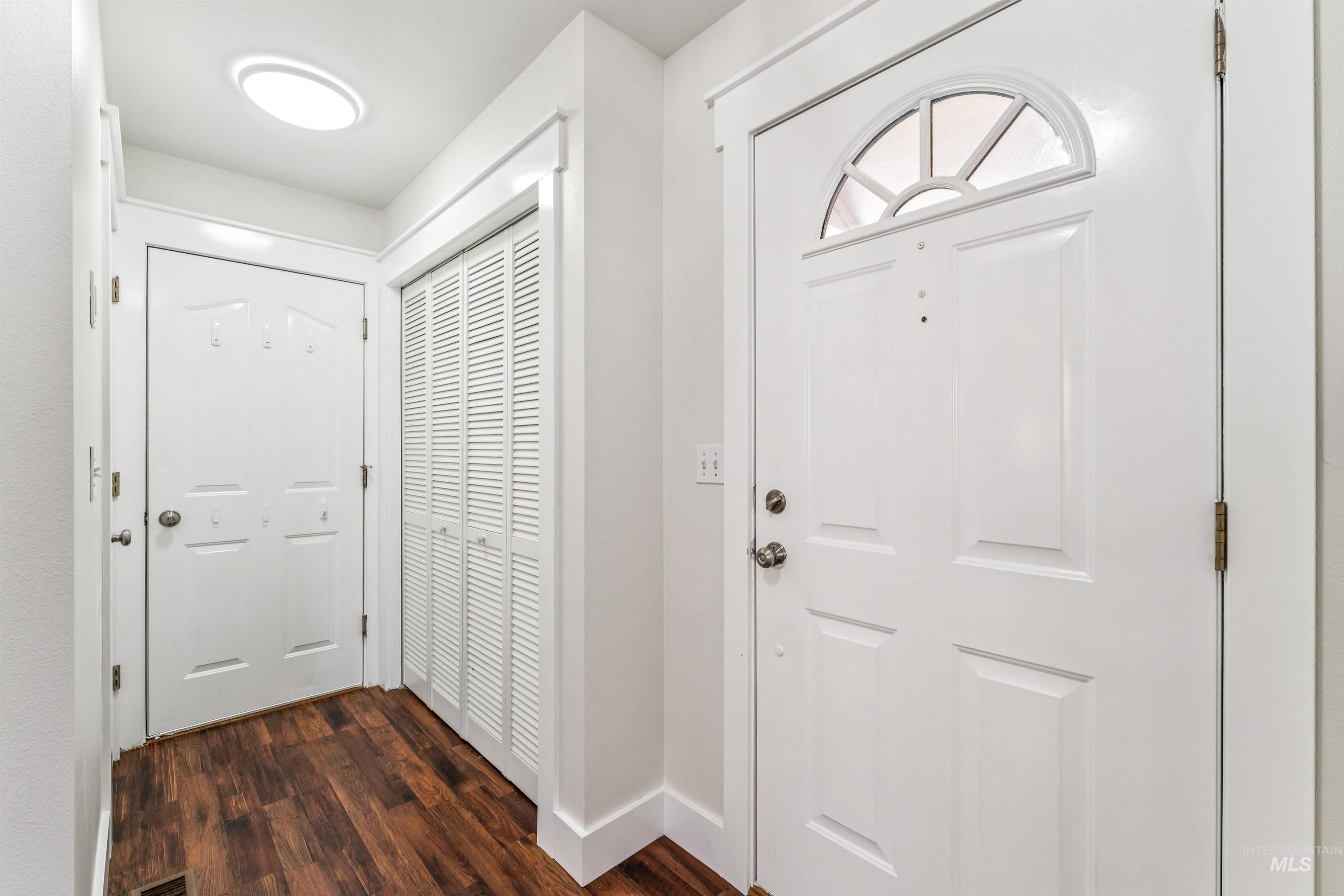 Entrance foyer featuring dark wood-style floors and baseboards