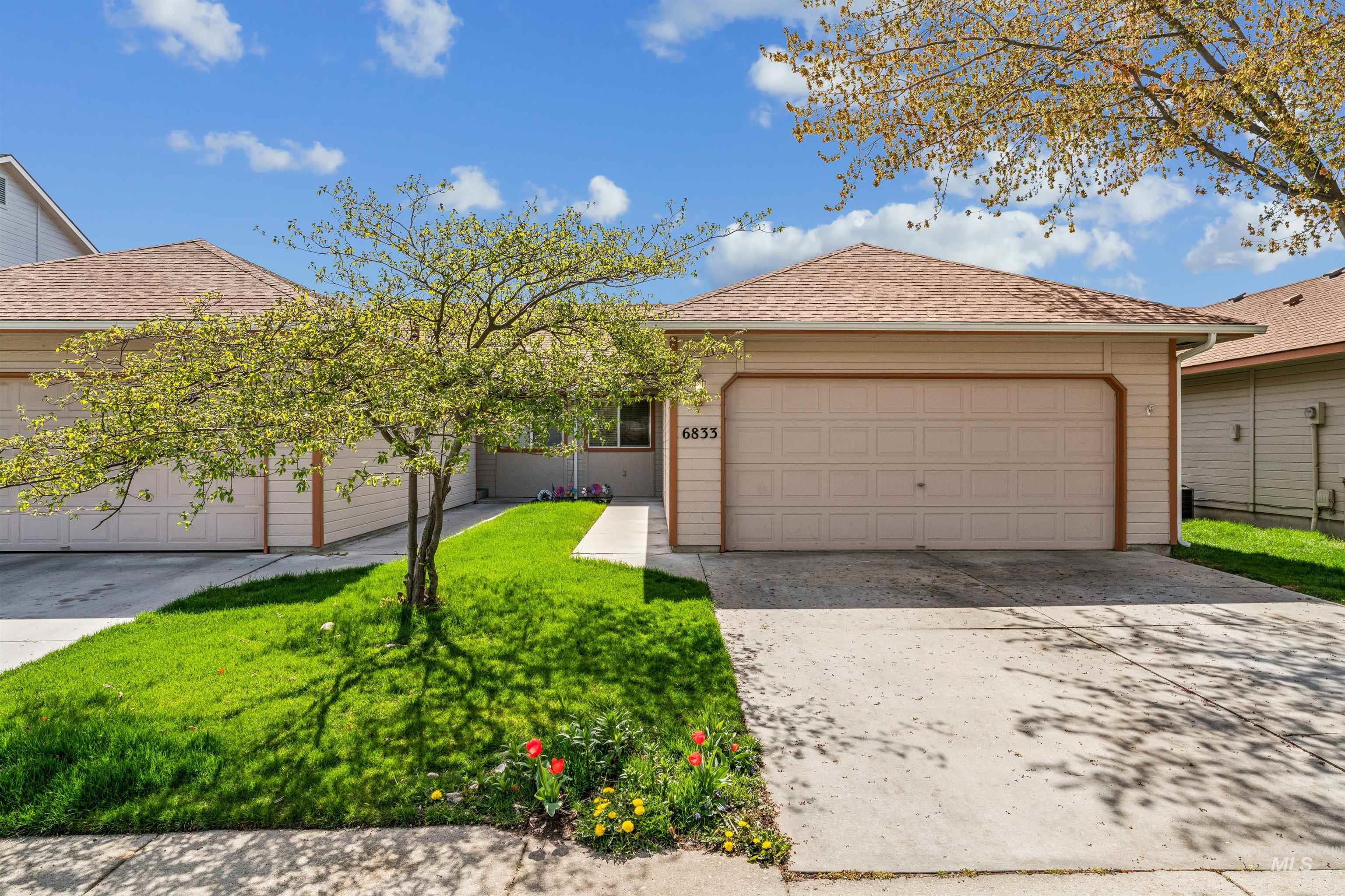 Ranch-style house featuring a shingled roof, concrete driveway, a garage, and a front yard