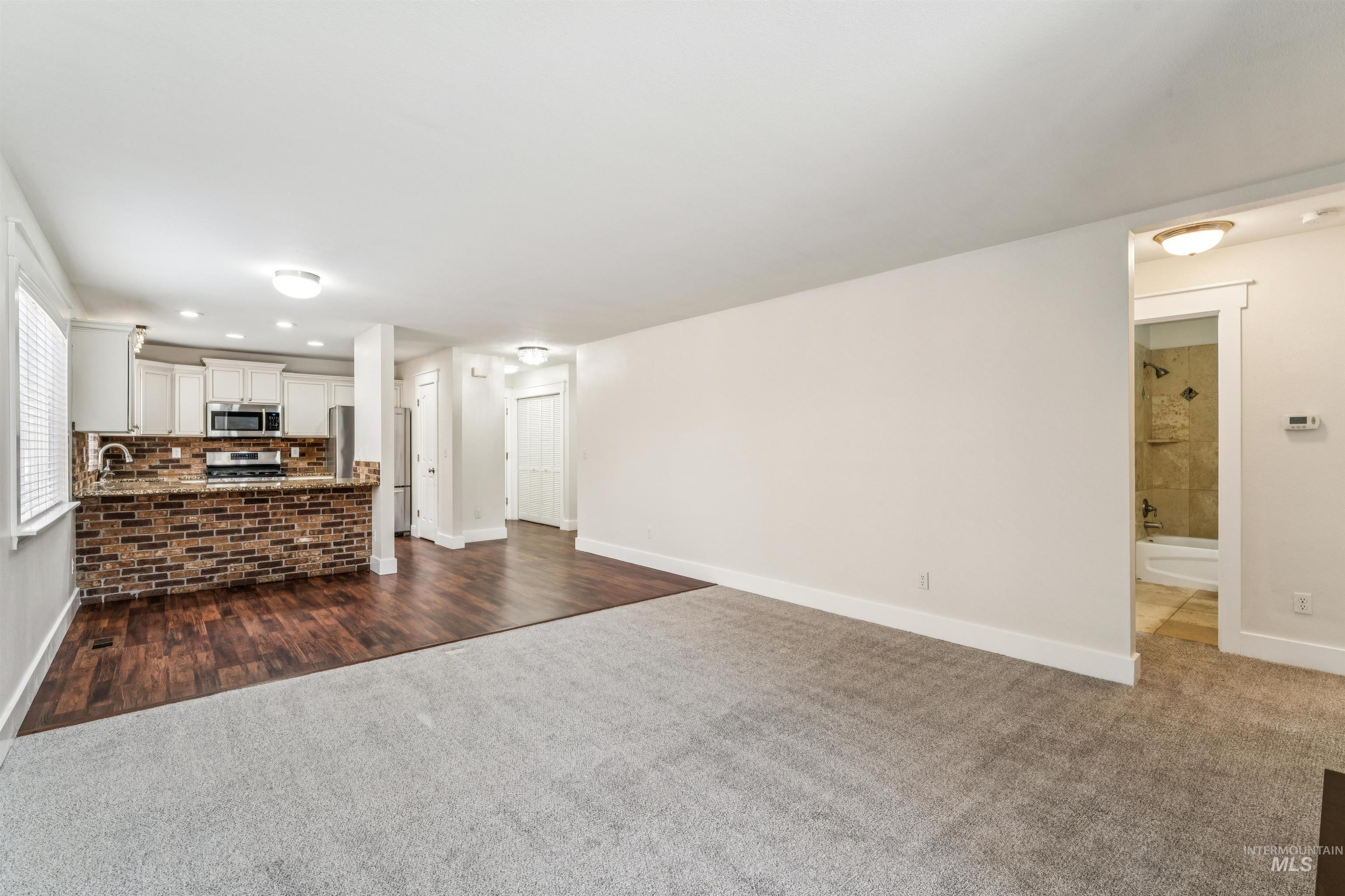 Unfurnished living room featuring dark carpet and recessed lighting