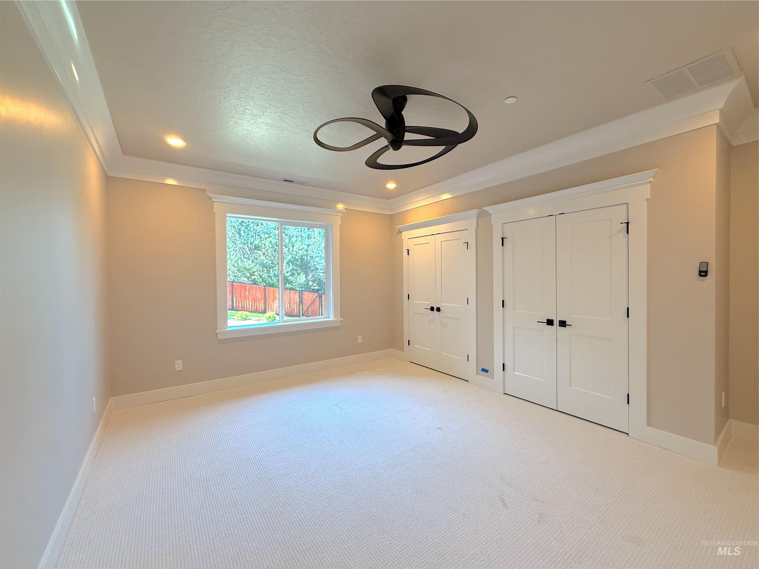 Unfurnished bedroom with multiple closets, carpet, recessed lighting, ceiling fan, and crown molding
