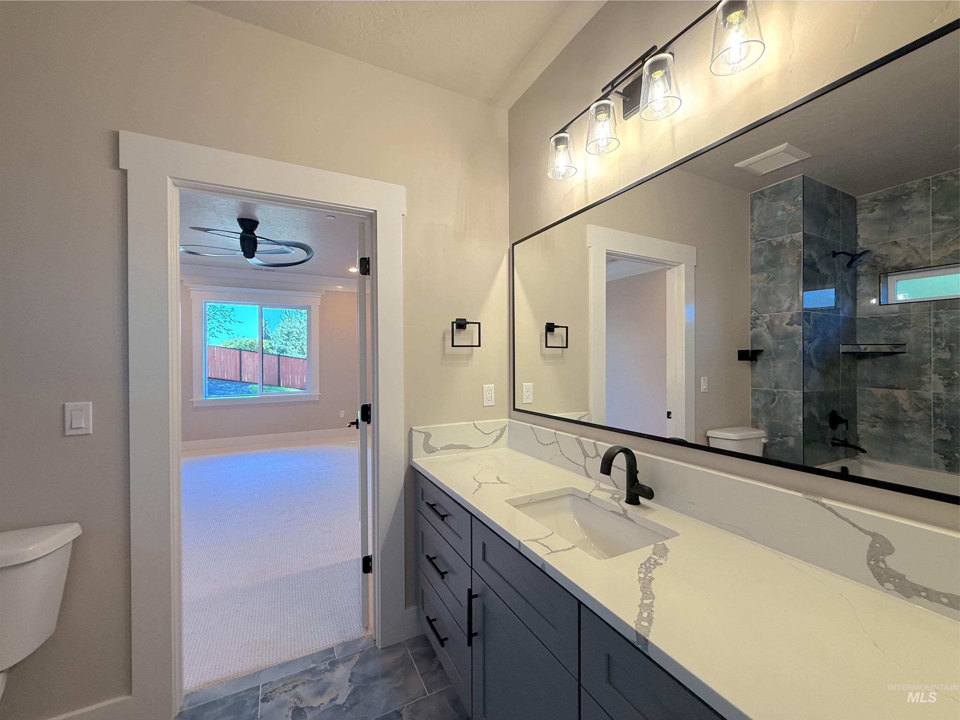 Bathroom featuring vanity, healthy amount of natural light, and shower / tub combination