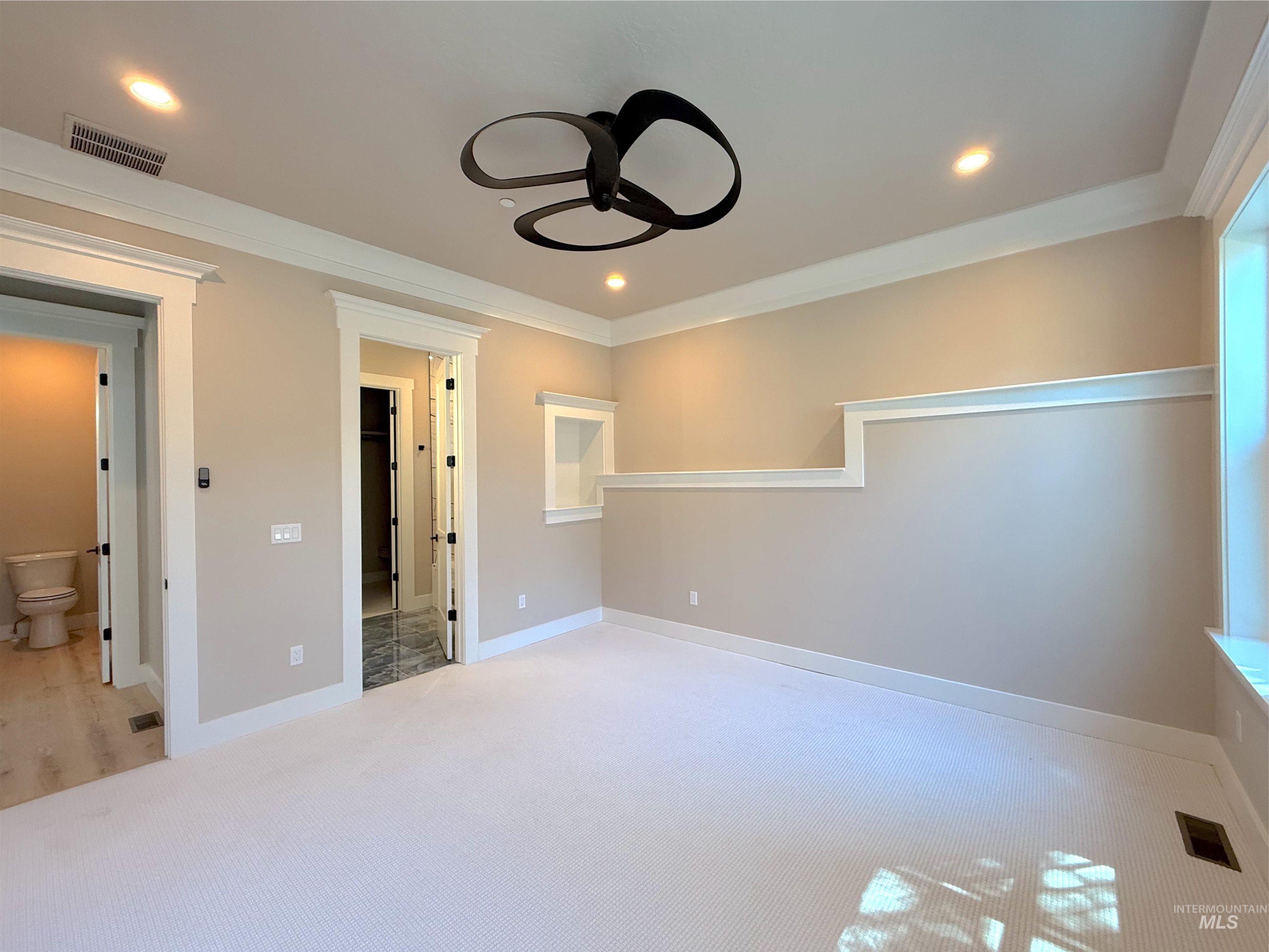 Spare room featuring light colored carpet, recessed lighting, ornamental molding, and ceiling fan