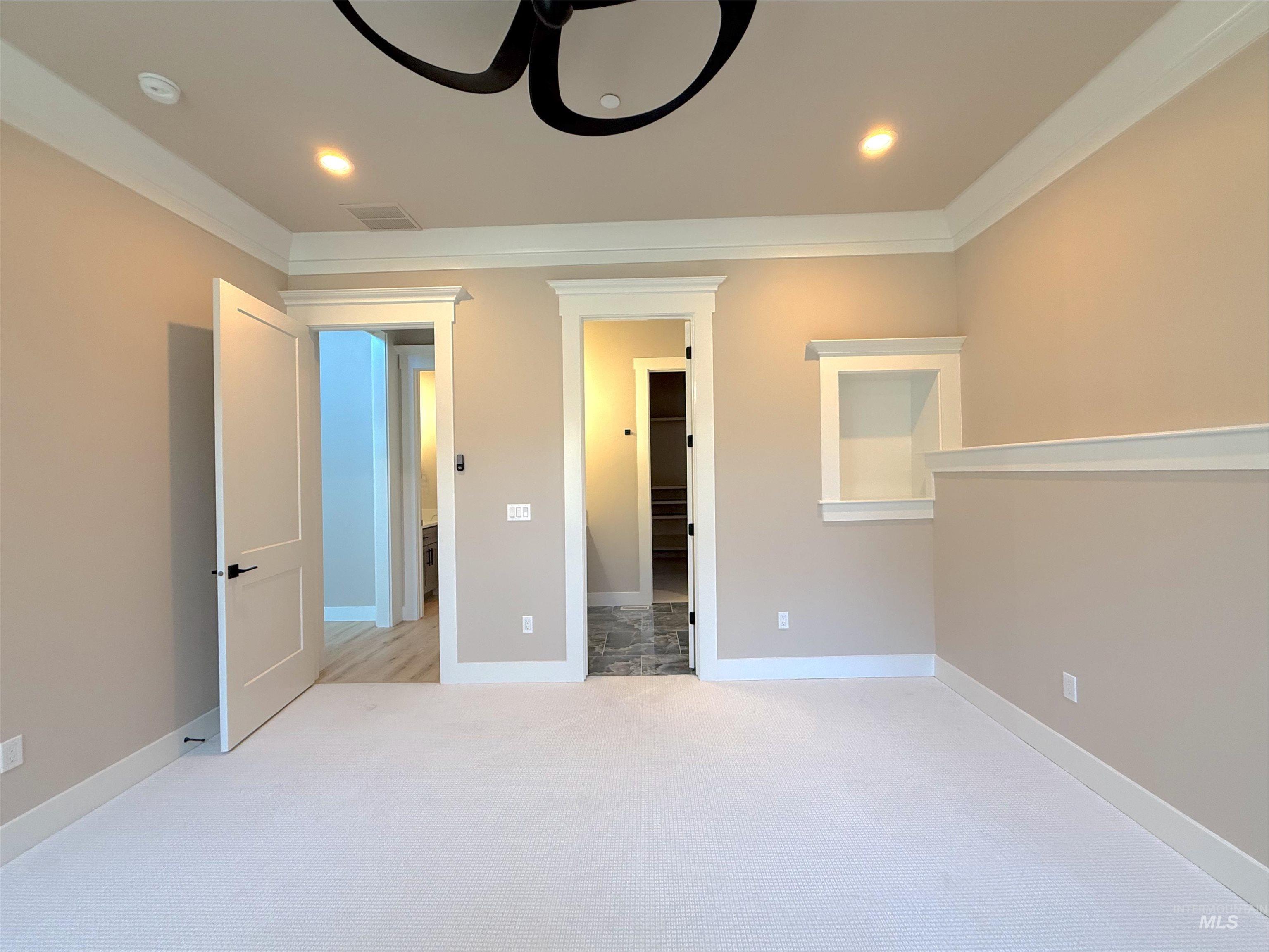 Unfurnished bedroom with light colored carpet, crown molding, ceiling fan, and recessed lighting
