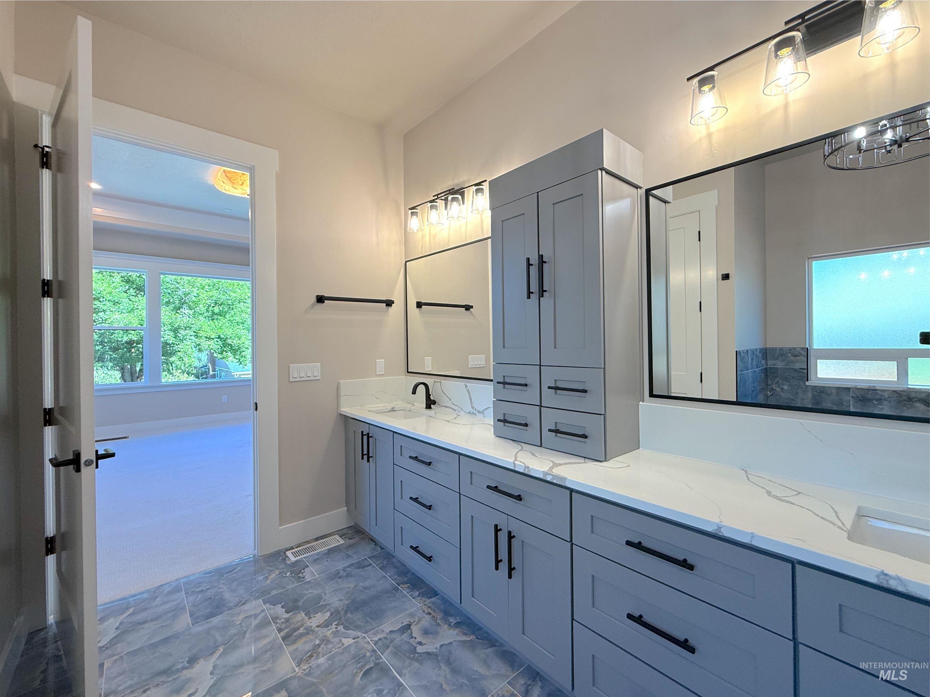 Bathroom featuring double vanity and baseboards
