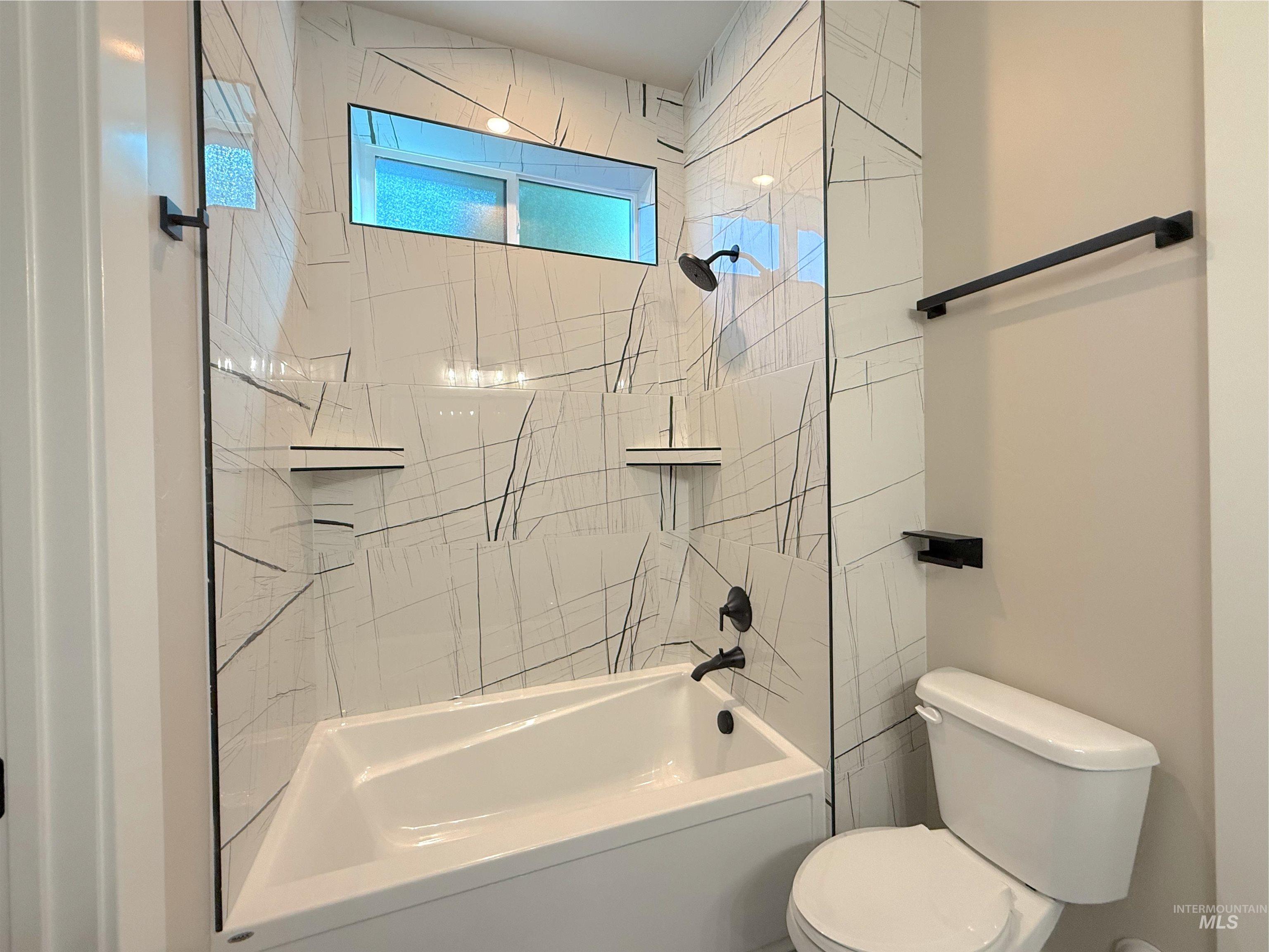 Bathroom featuring toilet and shower / bathtub combination