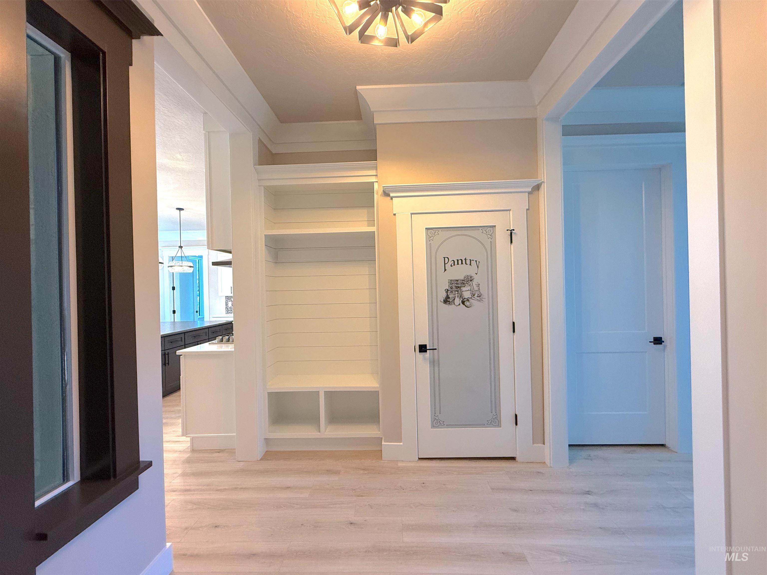 Mudroom with light wood finished floors and a textured ceiling