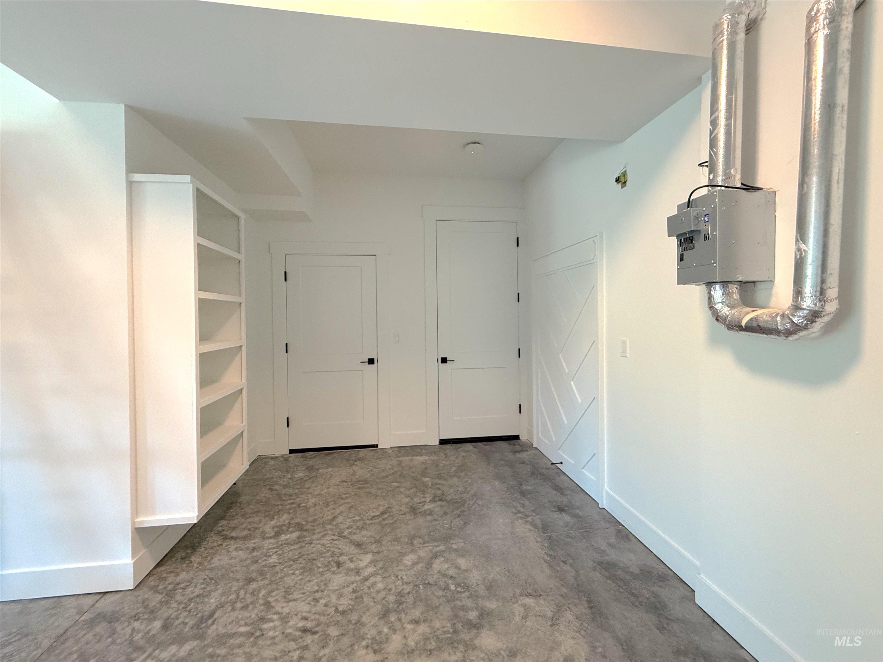Corridor with baseboards and concrete flooring
