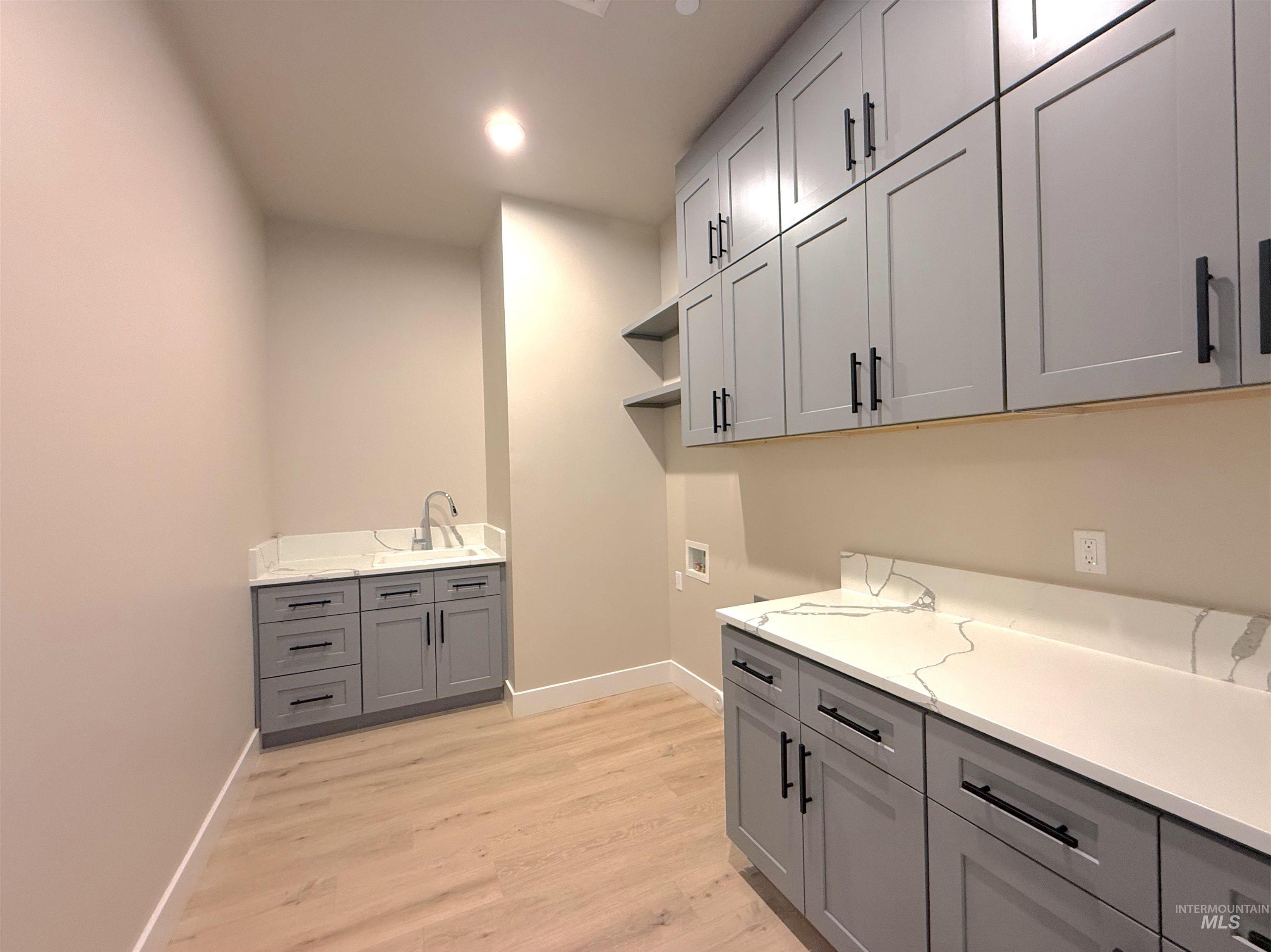 Laundry area with cabinet space, washer hookup, light wood-style floors, and recessed lighting