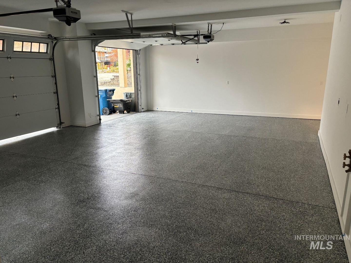 Garage featuring baseboards and a garage door opener