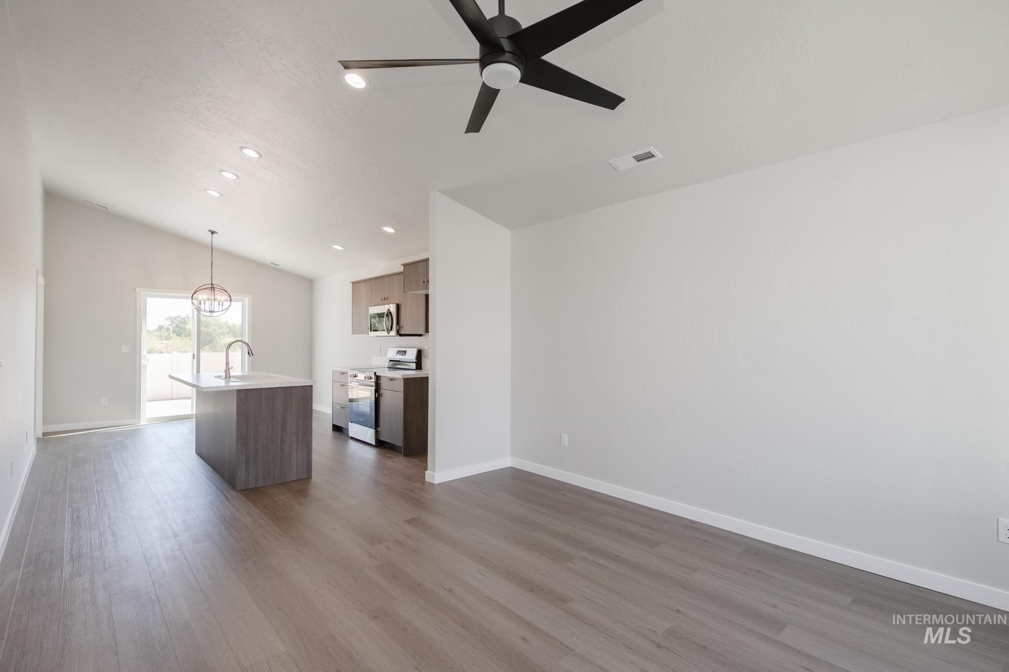 Unfurnished living room with vaulted ceiling, light wood finished floors, recessed lighting, and ceiling fan