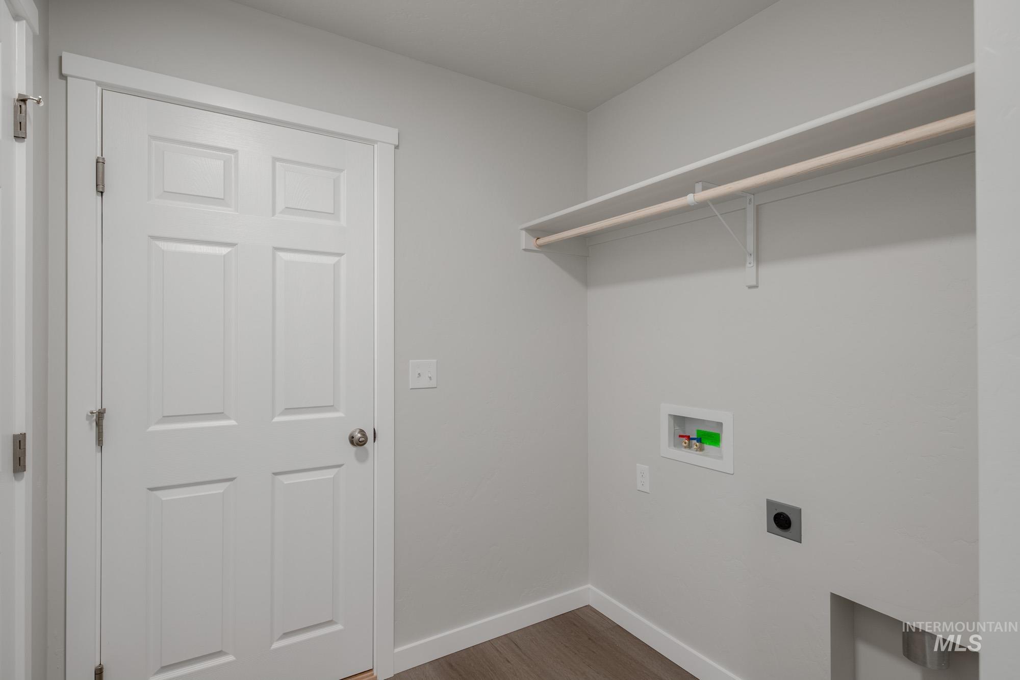Laundry area featuring light wood-type flooring, hookup for a washing machine, and electric dryer hookup