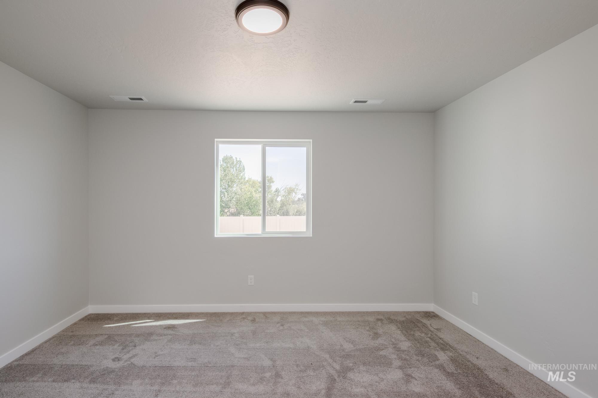 Empty room featuring light carpet and baseboards