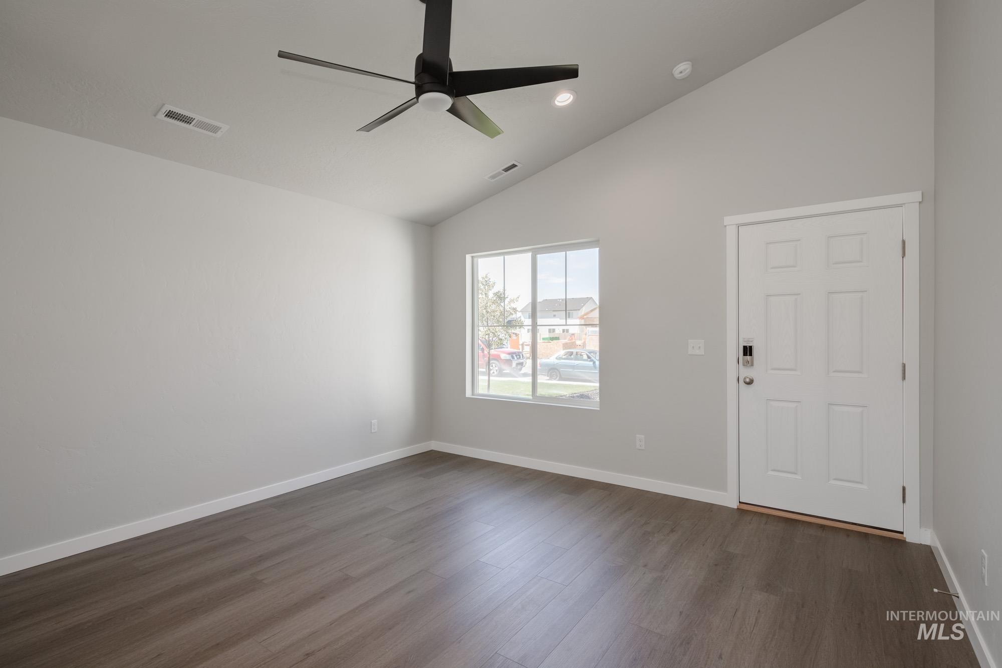 Spare room with lofted ceiling, dark wood-style flooring, a ceiling fan, and recessed lighting