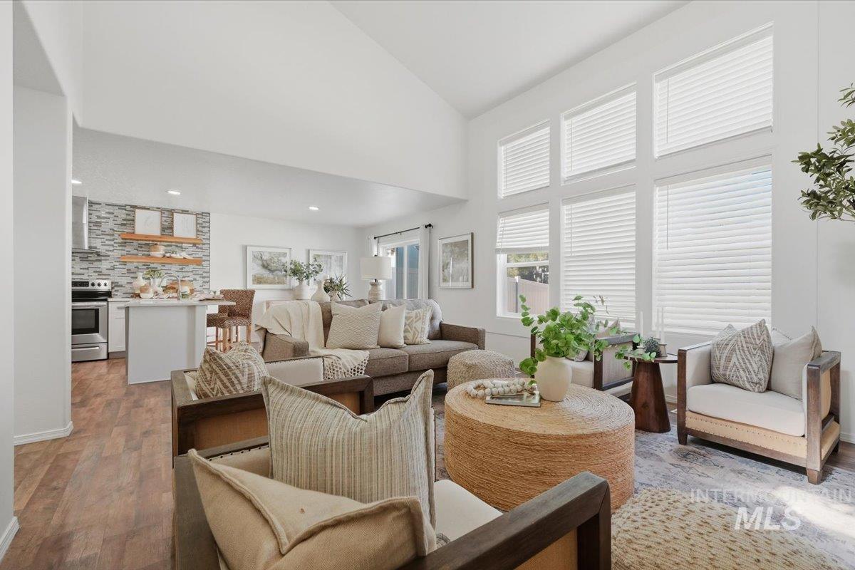 Living area featuring a vaulted ceiling and a wall of tall windows