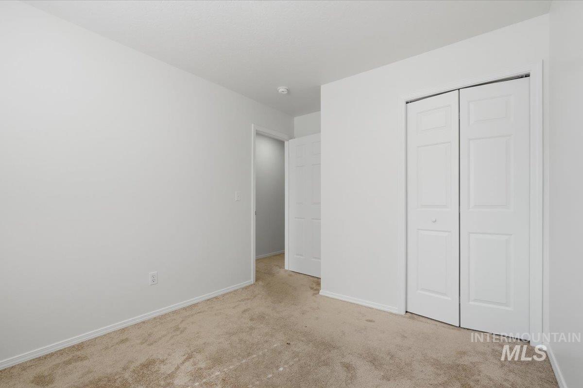 Neutral-toned carpet flooring and white painted walls characterize this interior space