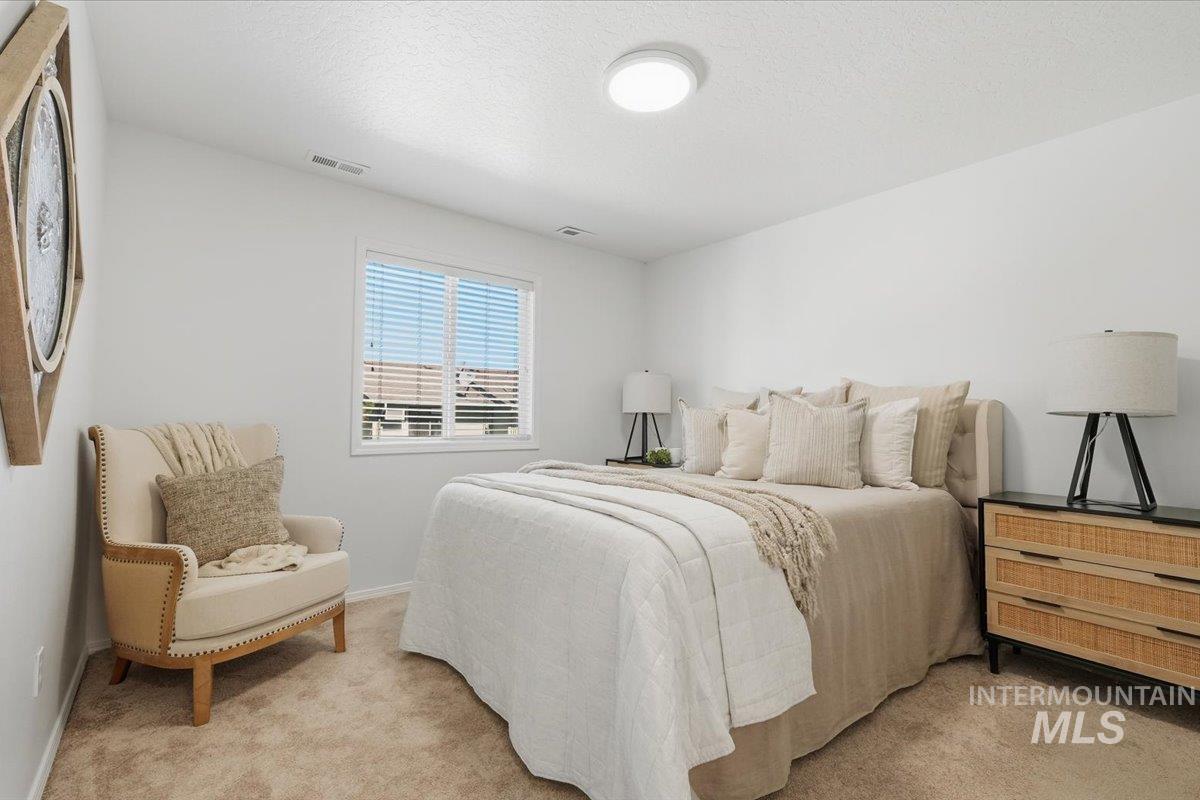 Carpeted room featuring a single window with blinds, overhead flush-mount lighting, and light-toned wall finishes