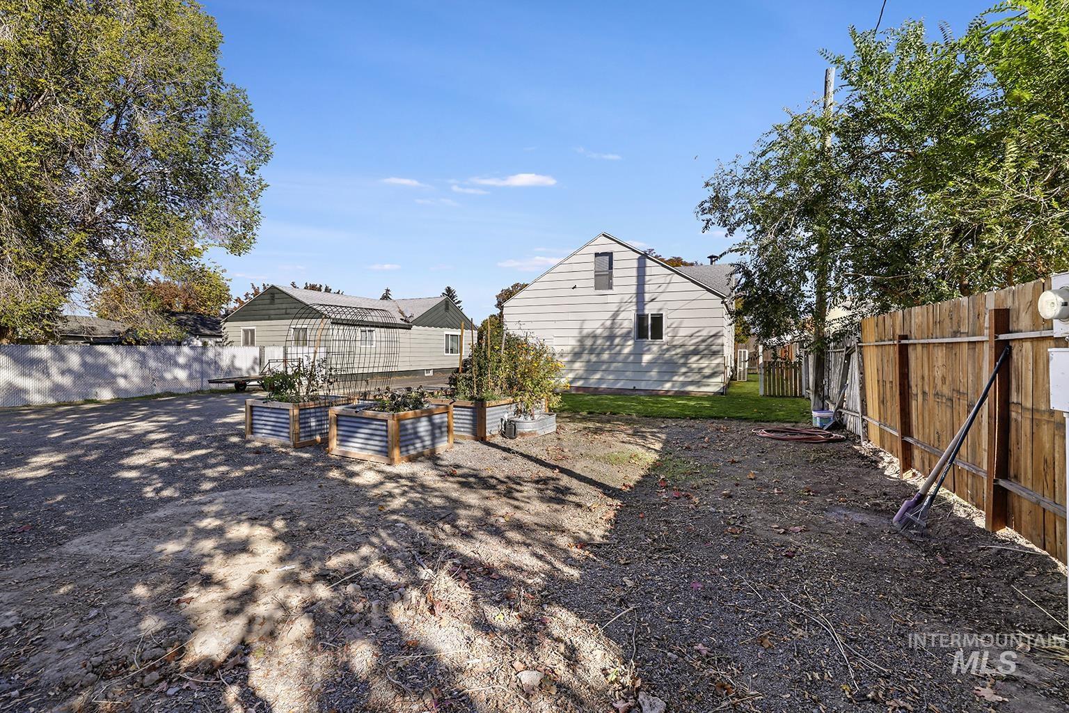 Back of house featuring a fenced backyard and a vegetable garden