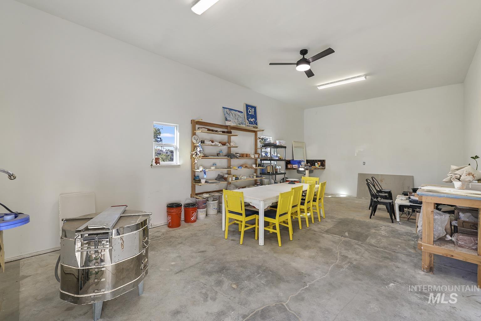 Dining area featuring concrete flooring and ceiling fan