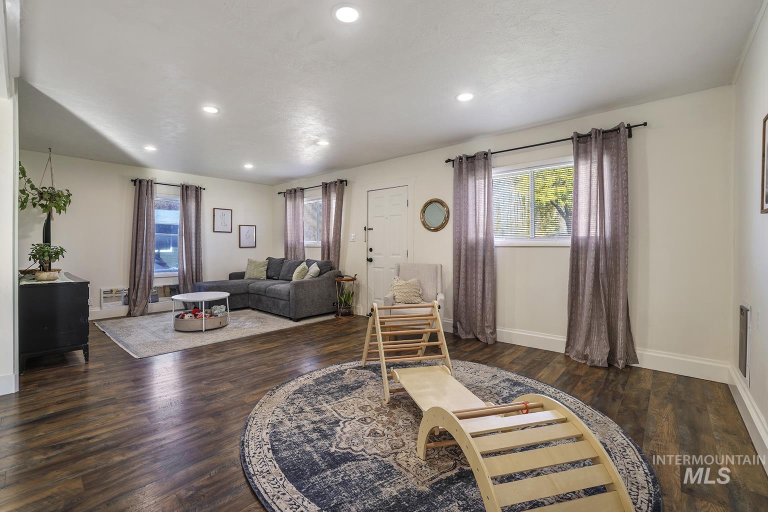 Living room with recessed lighting and dark wood-style flooring