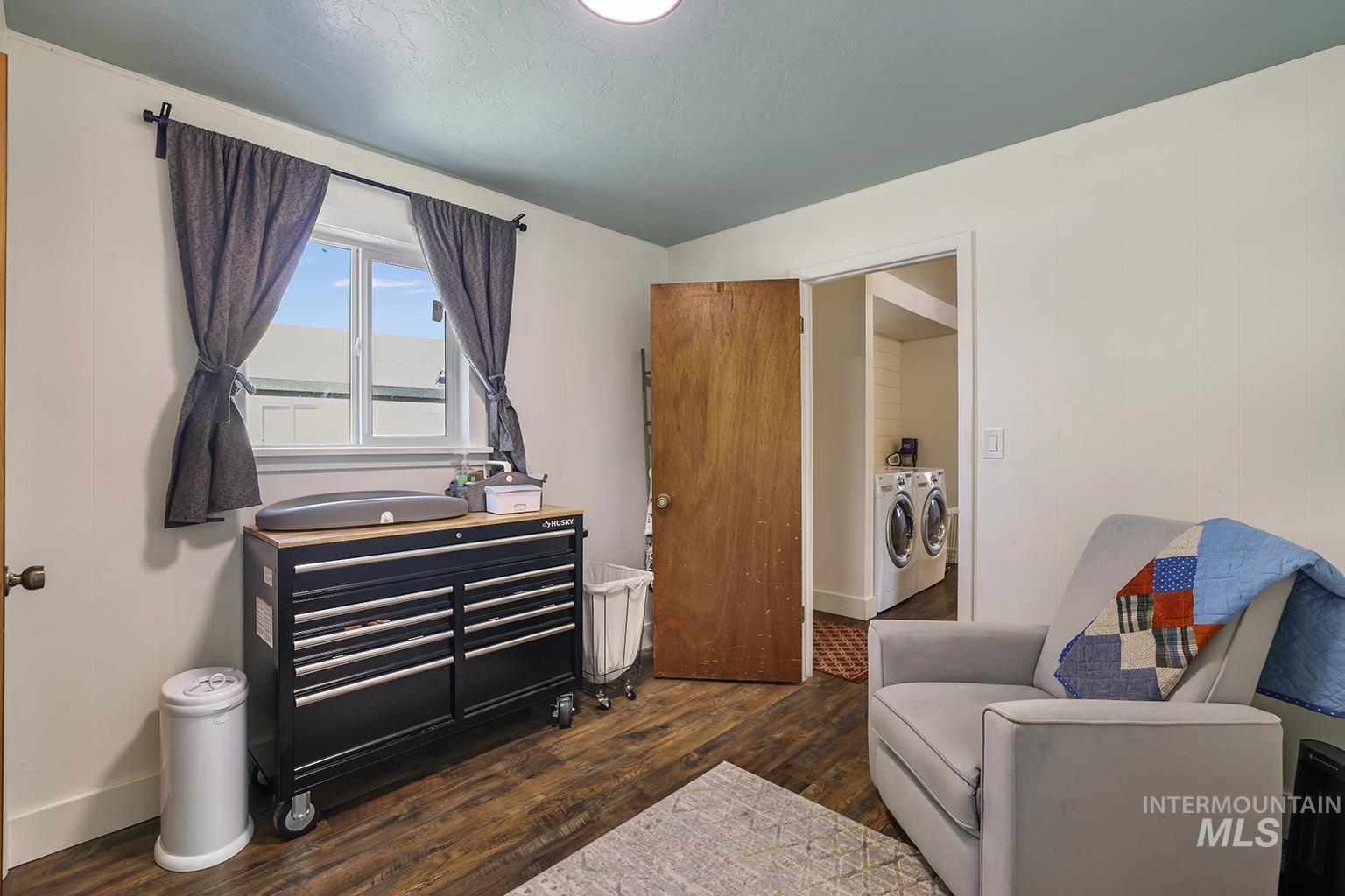 Living area featuring independent washer and dryer and dark wood-style floors