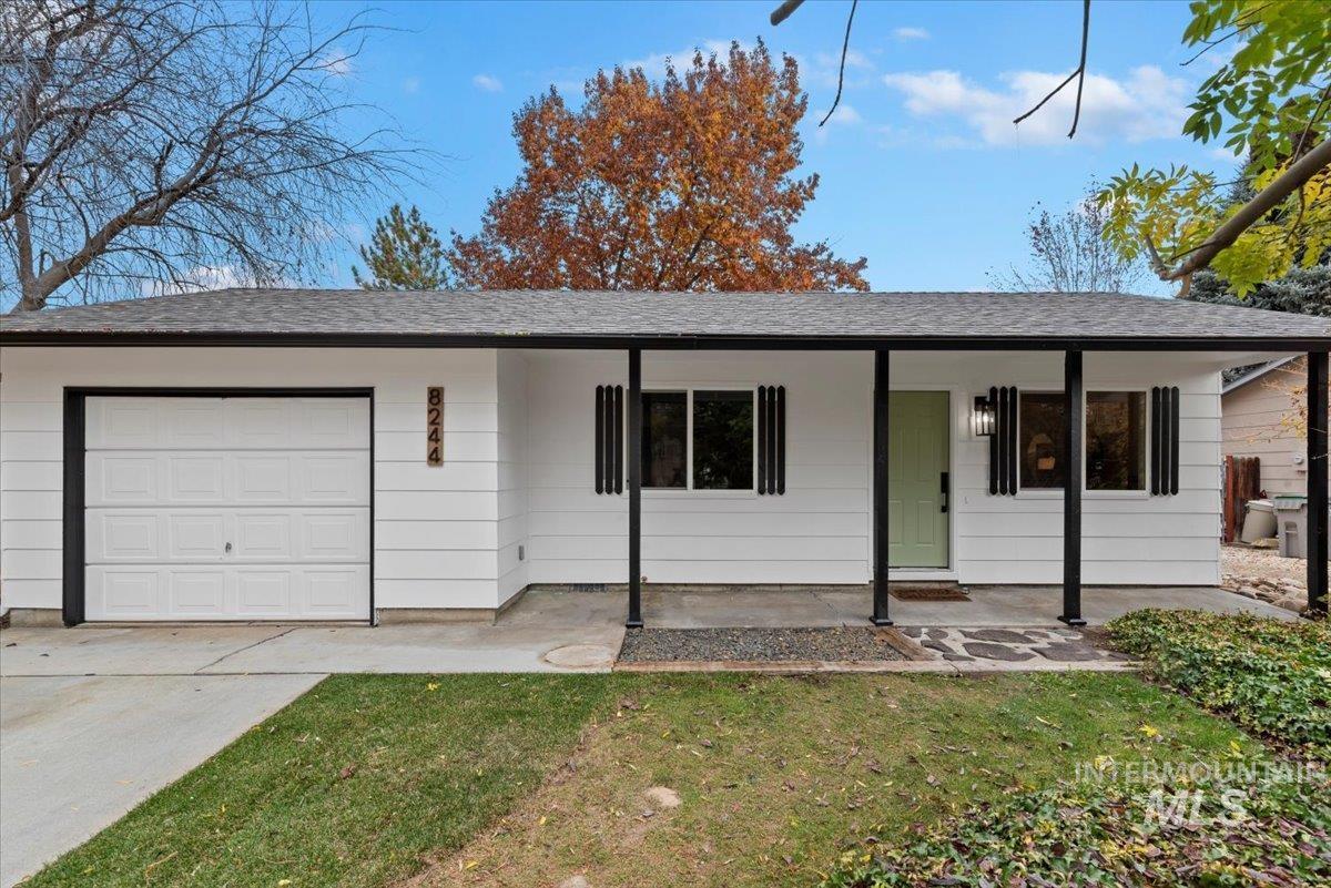 Ranch-style house with a front lawn, covered porch, driveway, and an attached garage