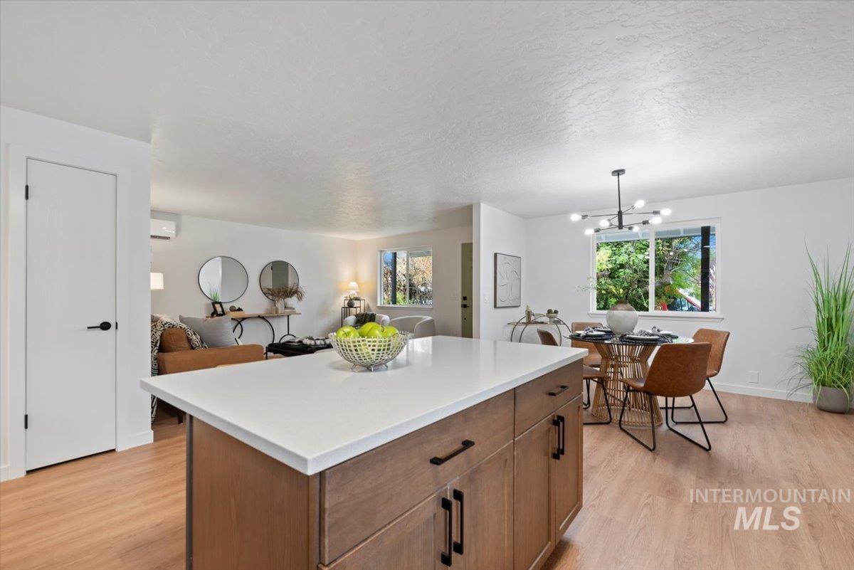 Kitchen with brown cabinets, a center island, light wood finished floors, open floor plan, and a chandelier