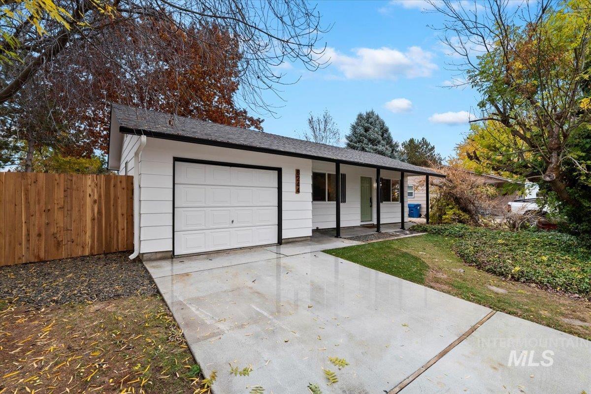 Ranch-style home with covered porch, concrete driveway, a garage, and a shingled roof