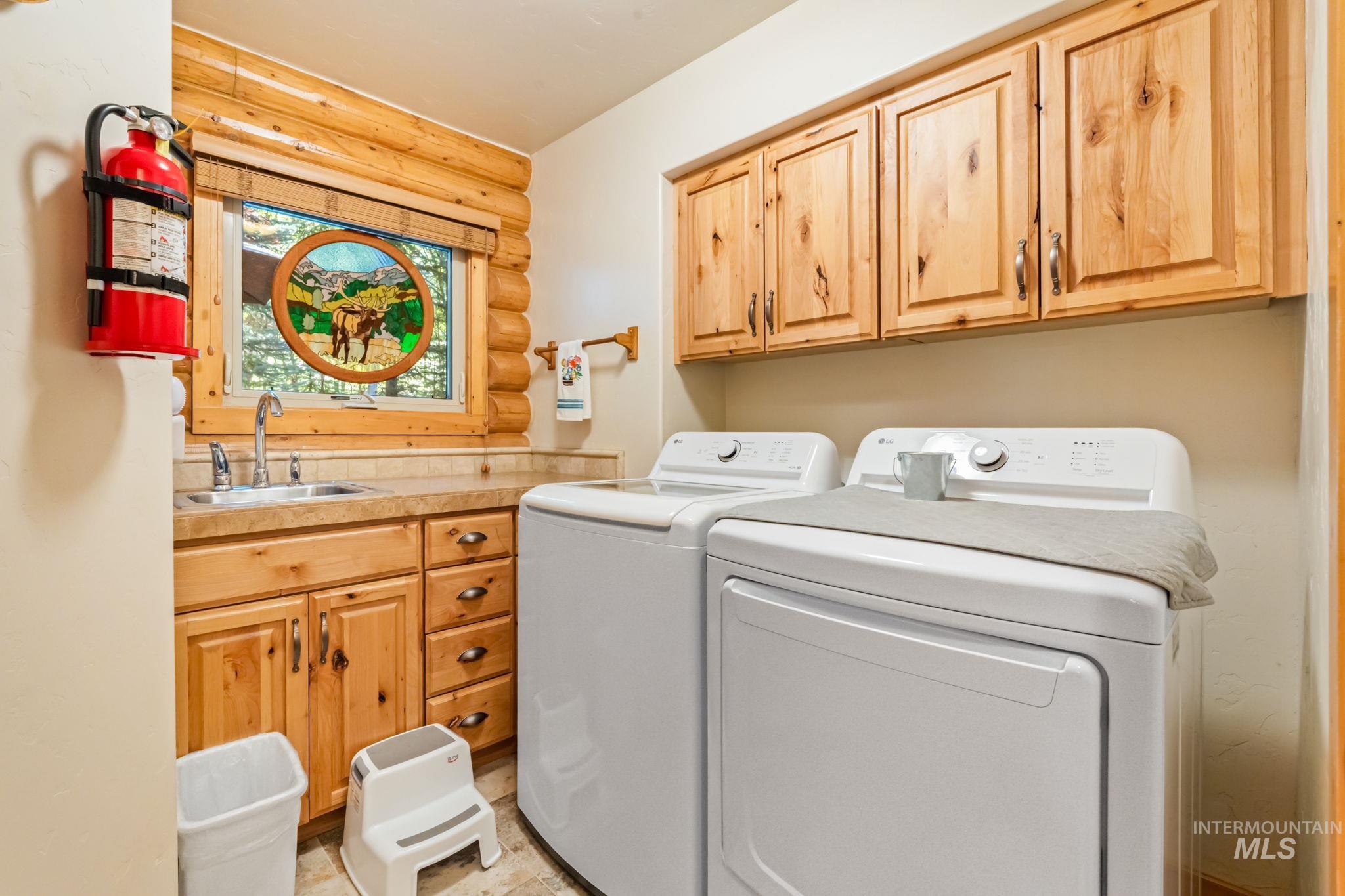 Washroom with washer and dryer, cabinet space, and rustic walls