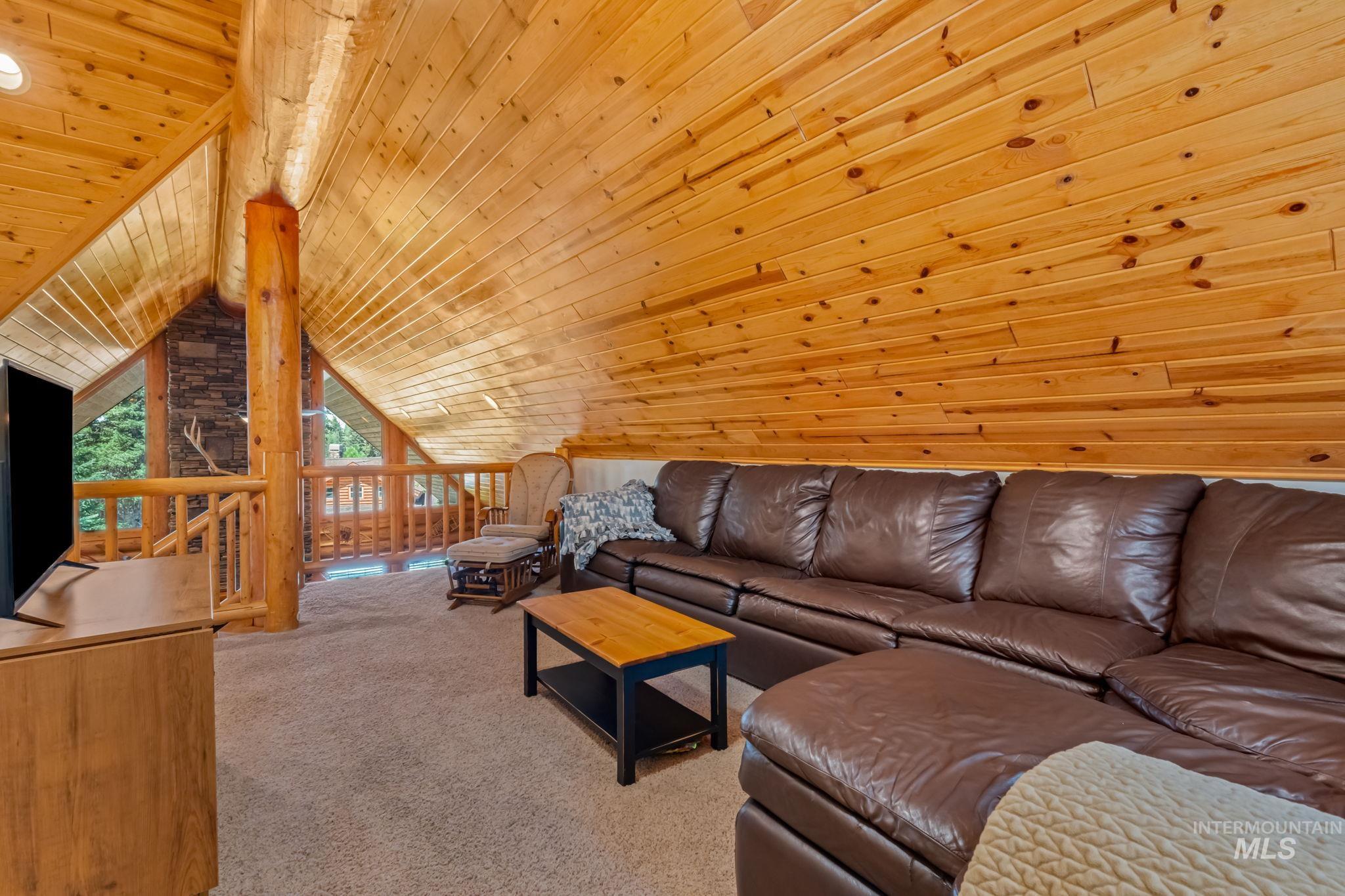 Carpeted living area with wood ceiling