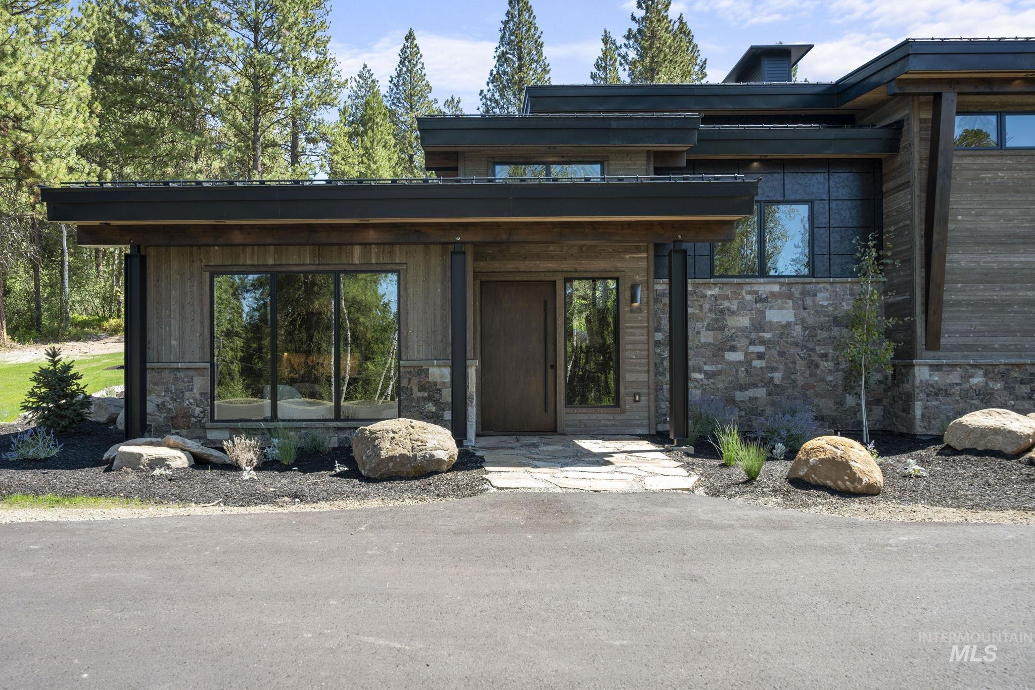 Entrance to property with stone siding and a chimney