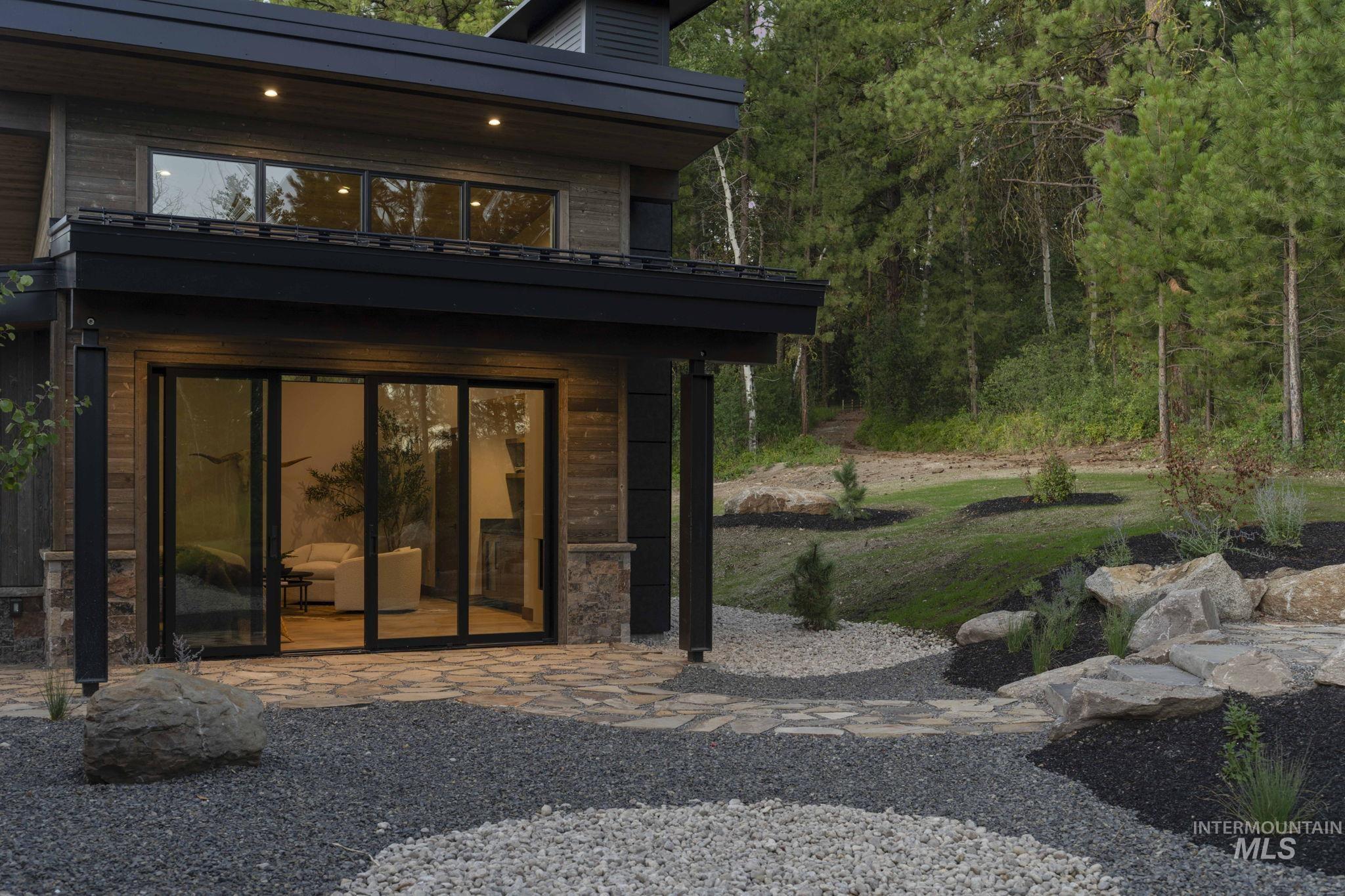 Back of property featuring a balcony, a patio area, and a yard