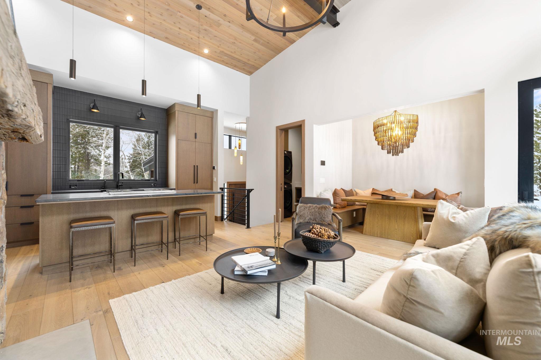 Living area featuring wooden ceiling, a chandelier, high vaulted ceiling, and light wood-style floors