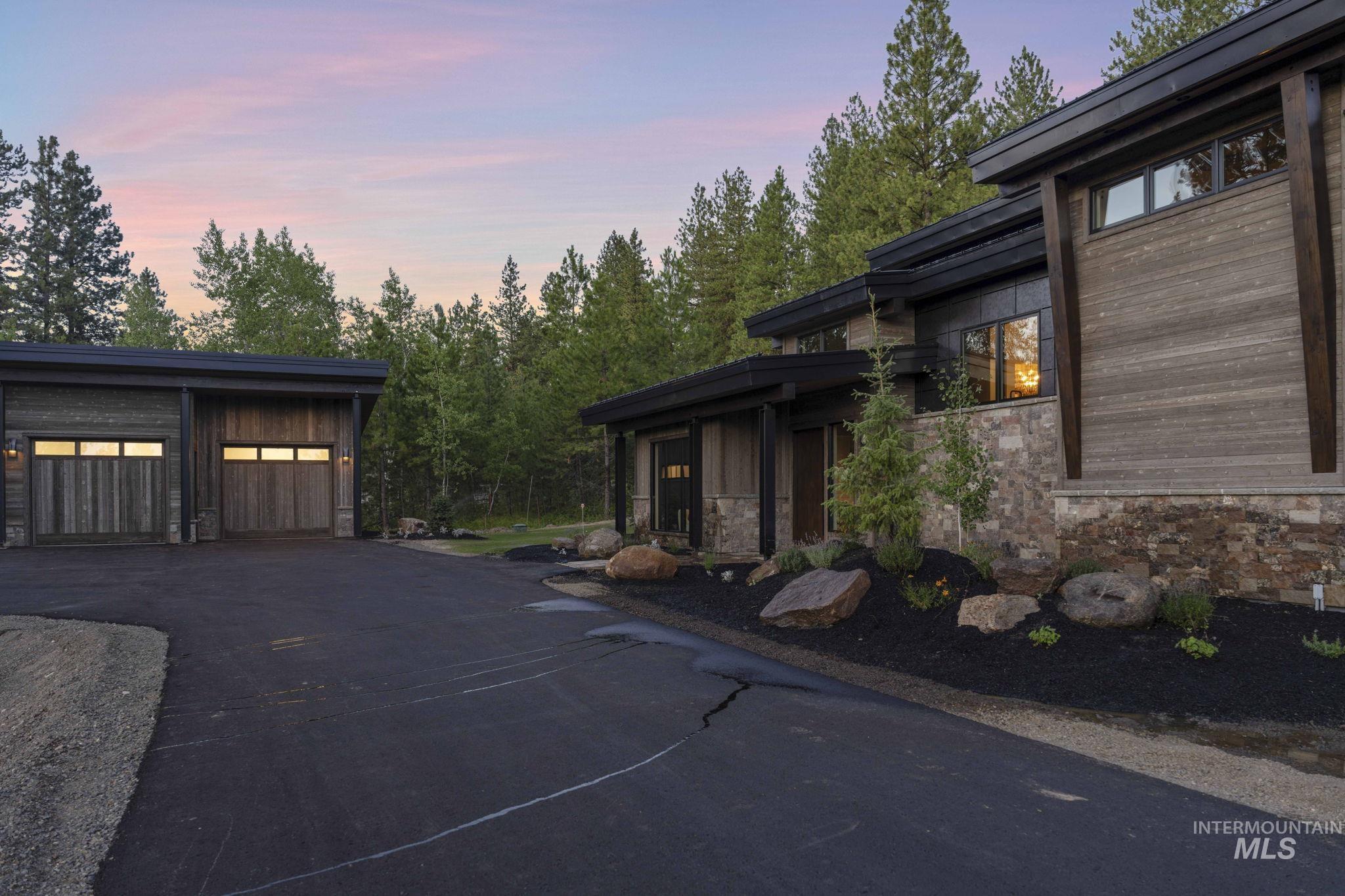View of side of home with stone siding, a garage, and an outdoor structure