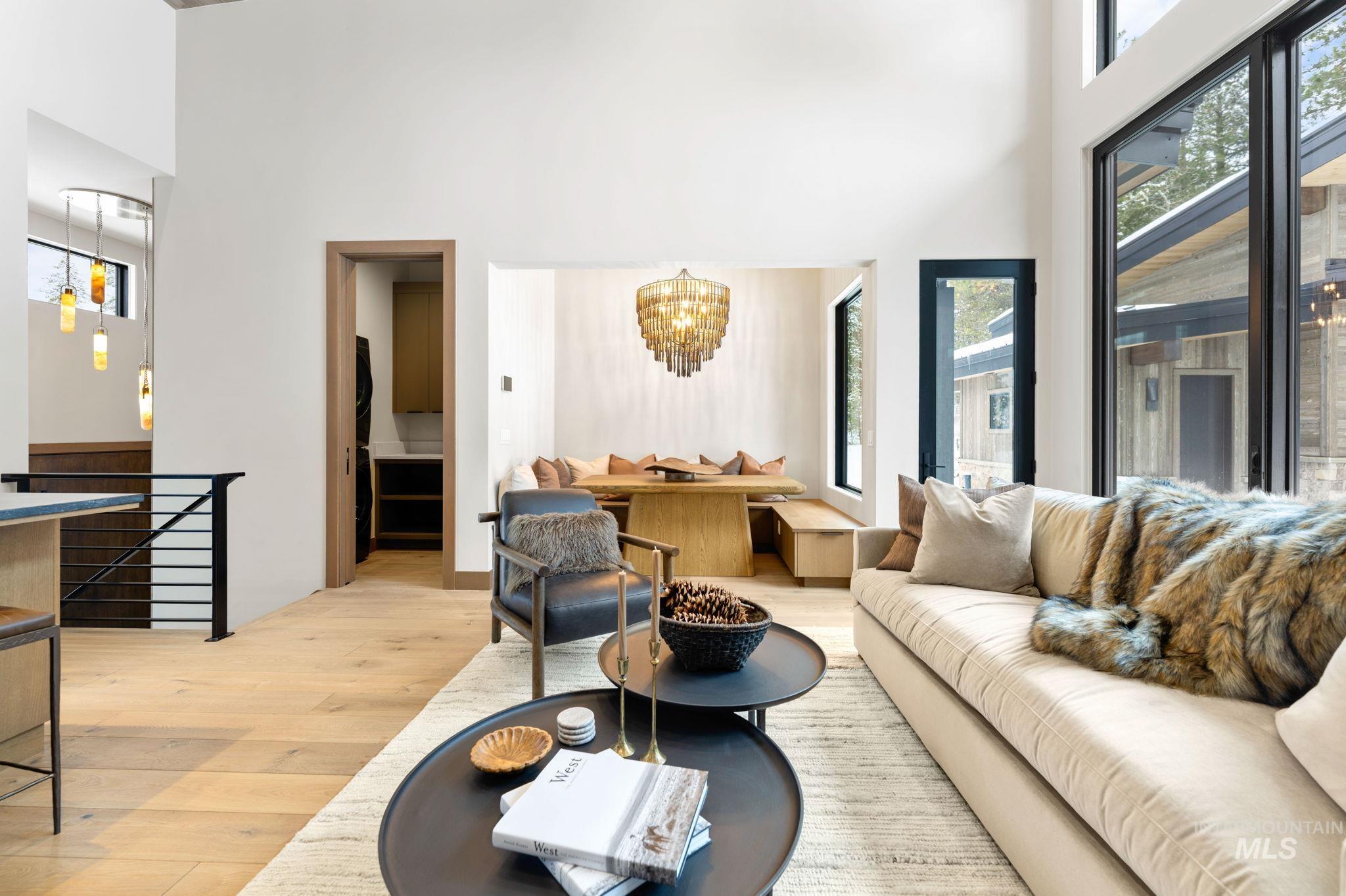 Living area with a chandelier, a towering ceiling, and light wood finished floors