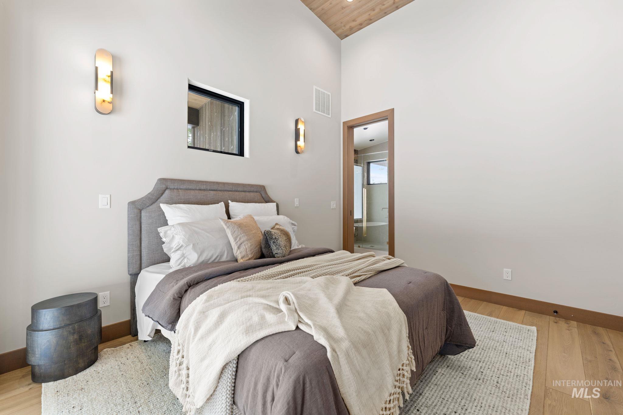 Bedroom featuring hardwood / wood-style floors and ensuite bathroom