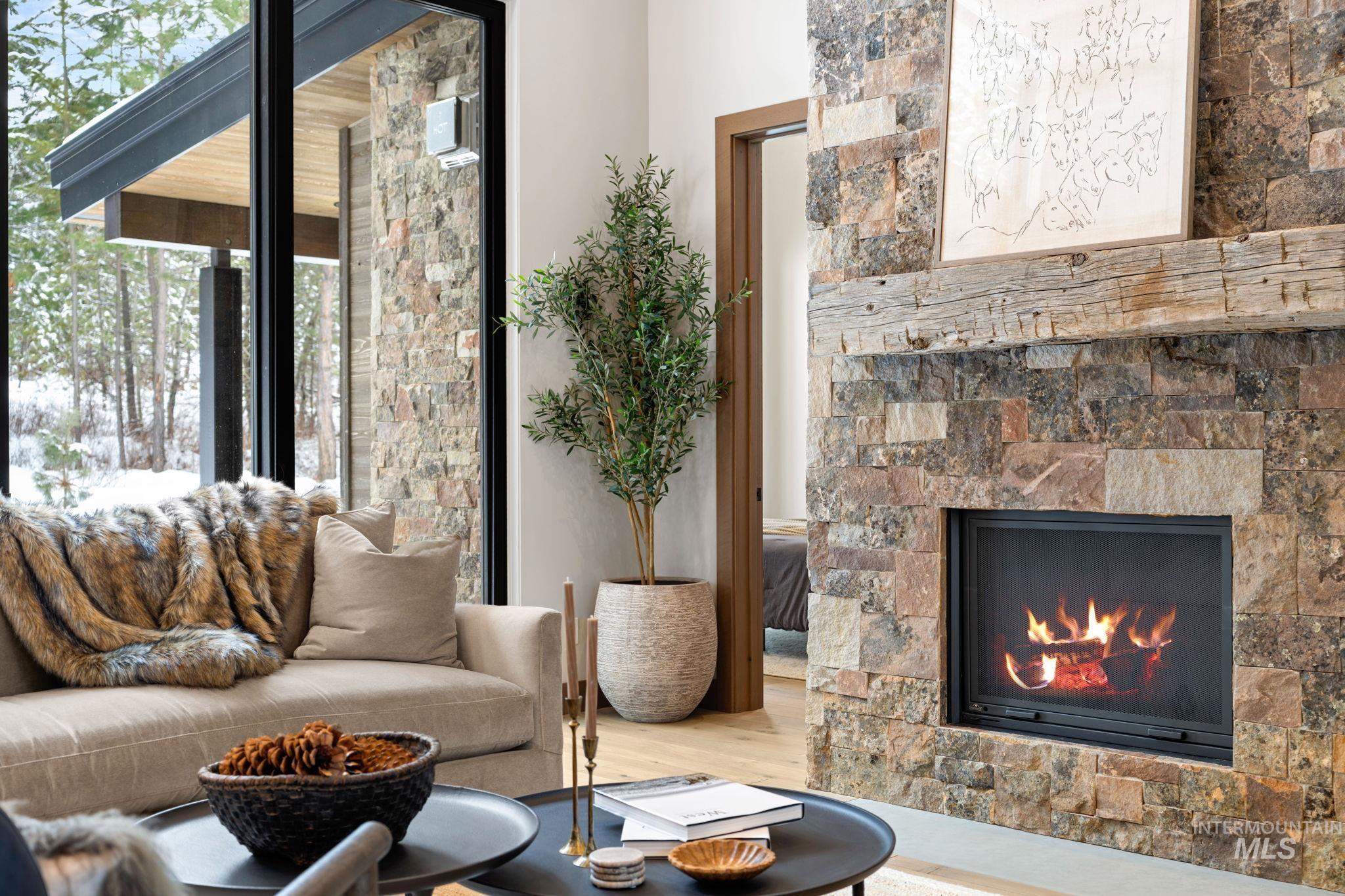 Living room with a lit fireplace and wood finished floors