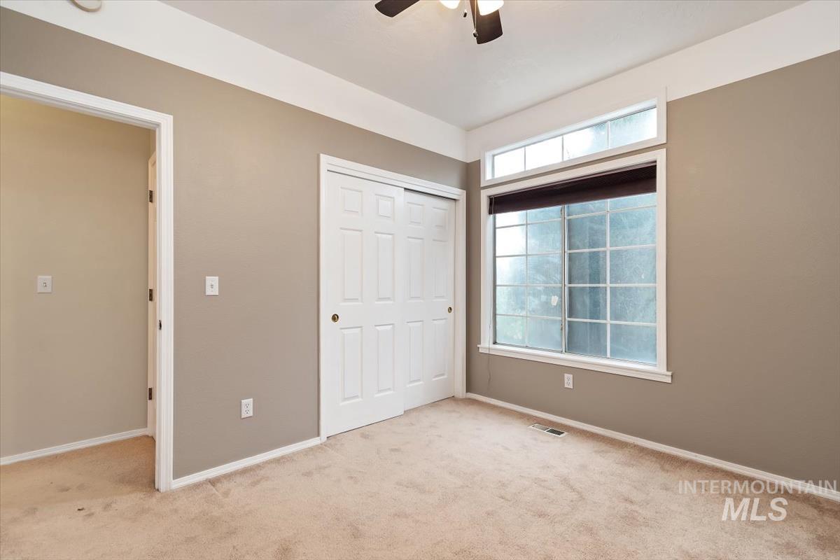 Unfurnished bedroom featuring a closet, carpet, and a ceiling fan