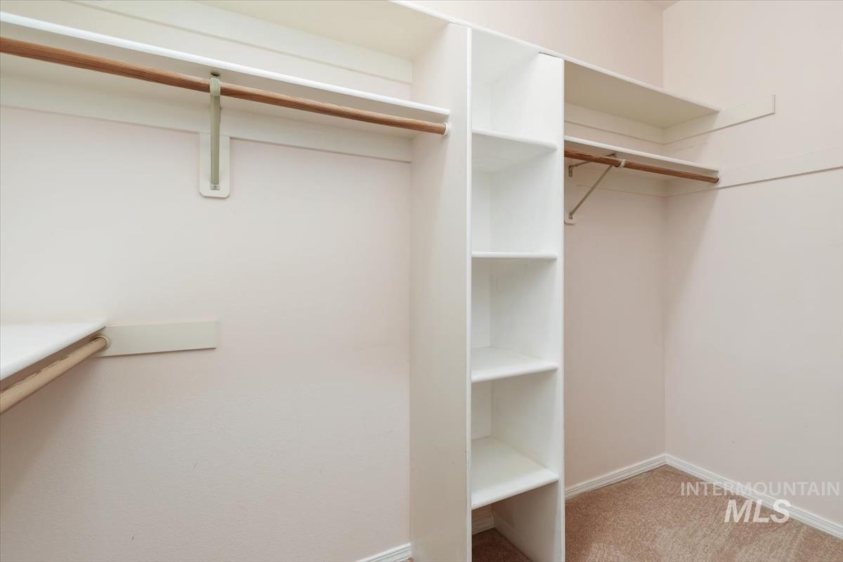 Walk in closet featuring light colored carpet