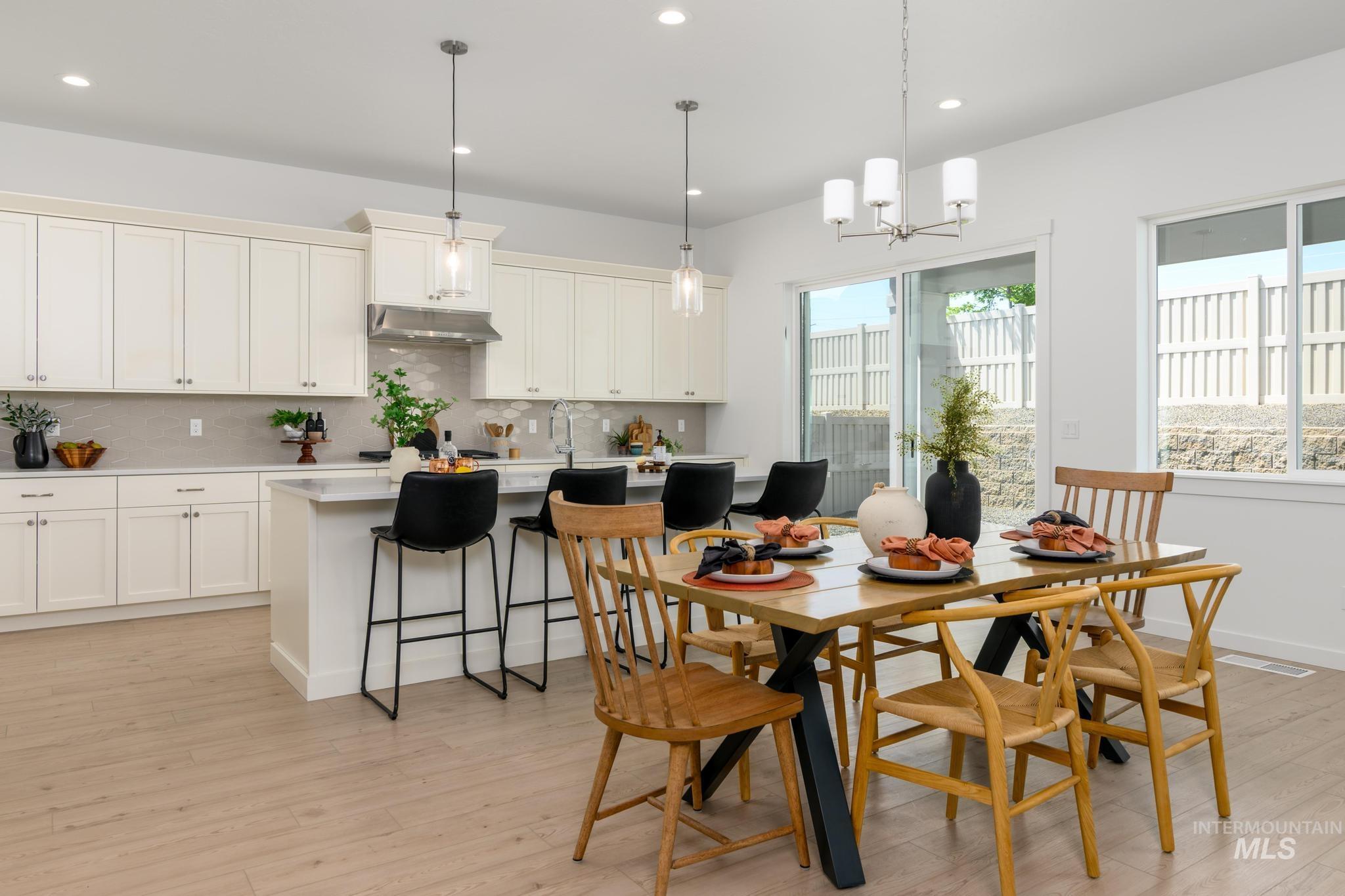 Dining space featuring light wood-style floors, recessed lighting, and a chandelier