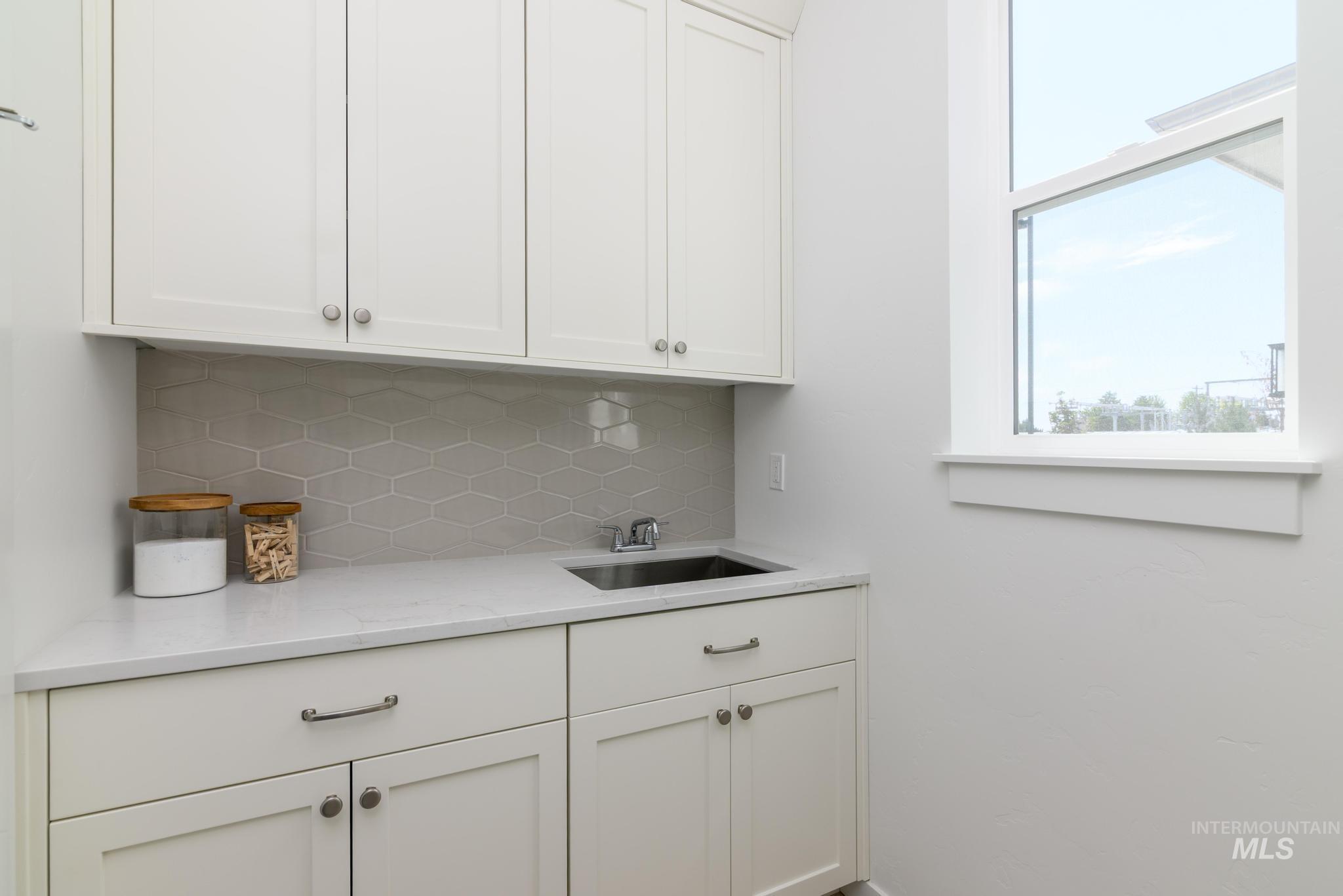 Bar featuring backsplash and a sink