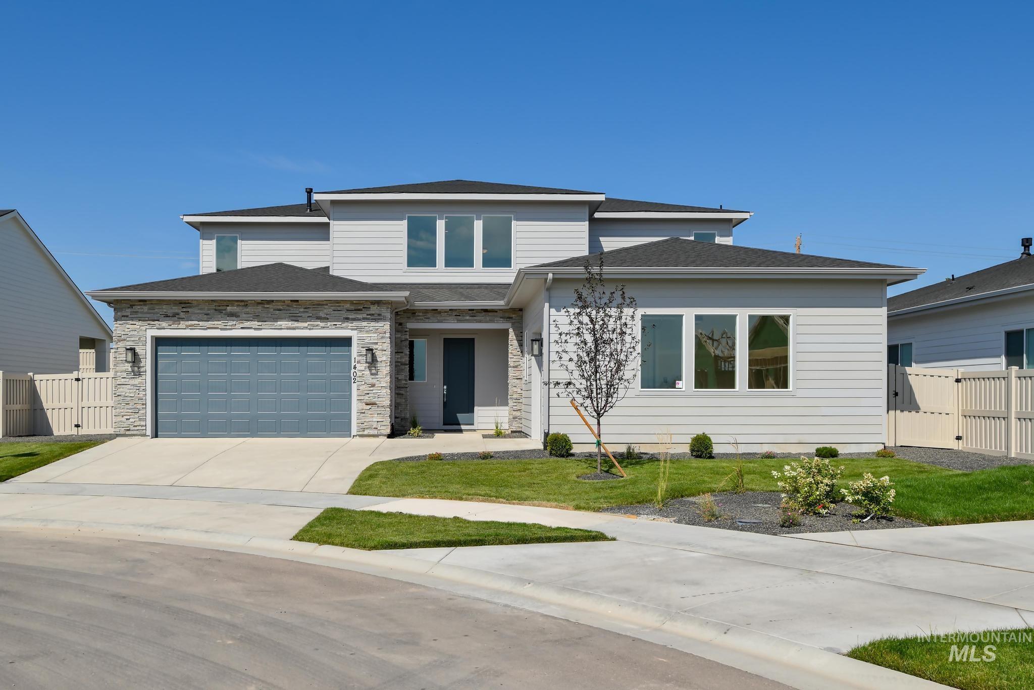 Prairie-style home with driveway, stone siding, a gate, and a shingled roof