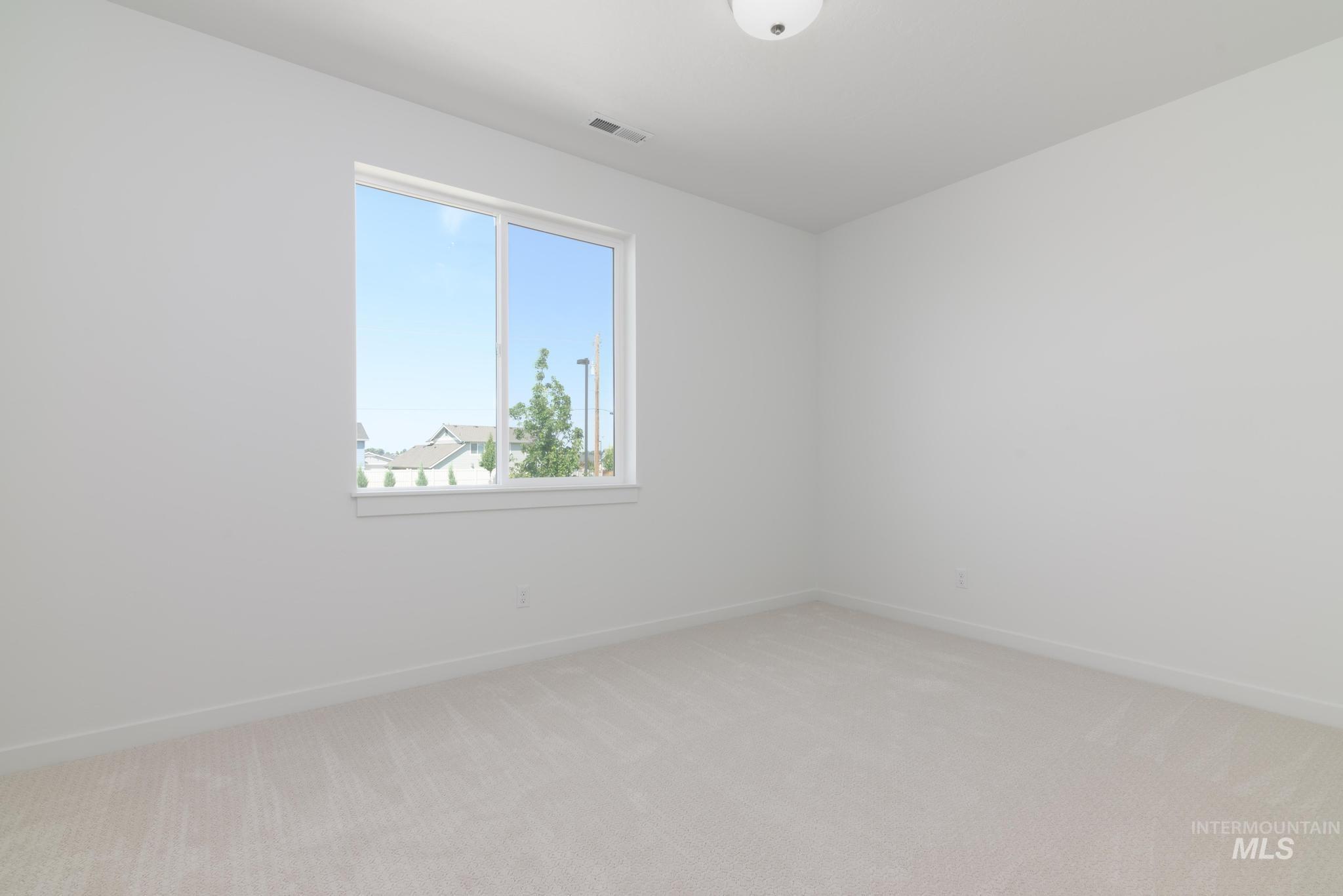 Empty room featuring light colored carpet