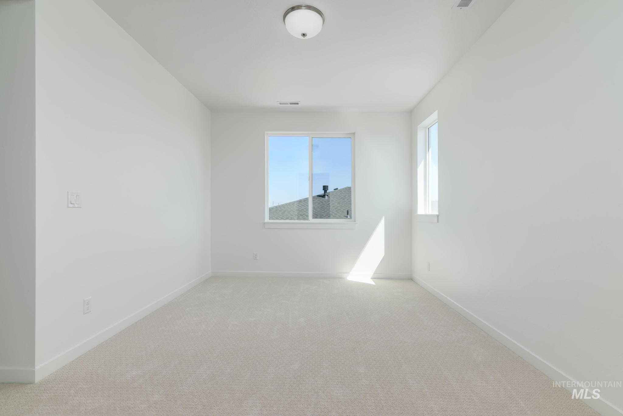 Spare room featuring carpet floors and baseboards