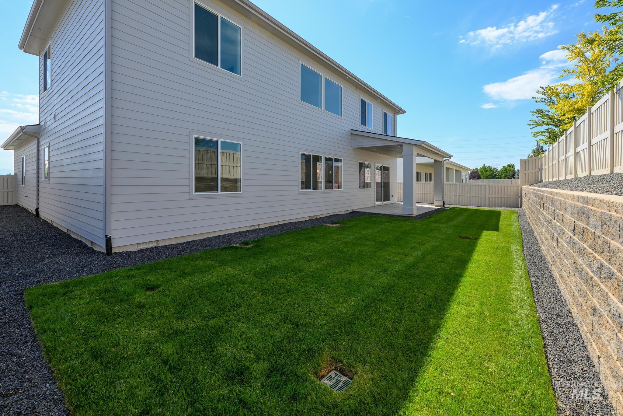 Rear view of house featuring a fenced backyard and a patio area