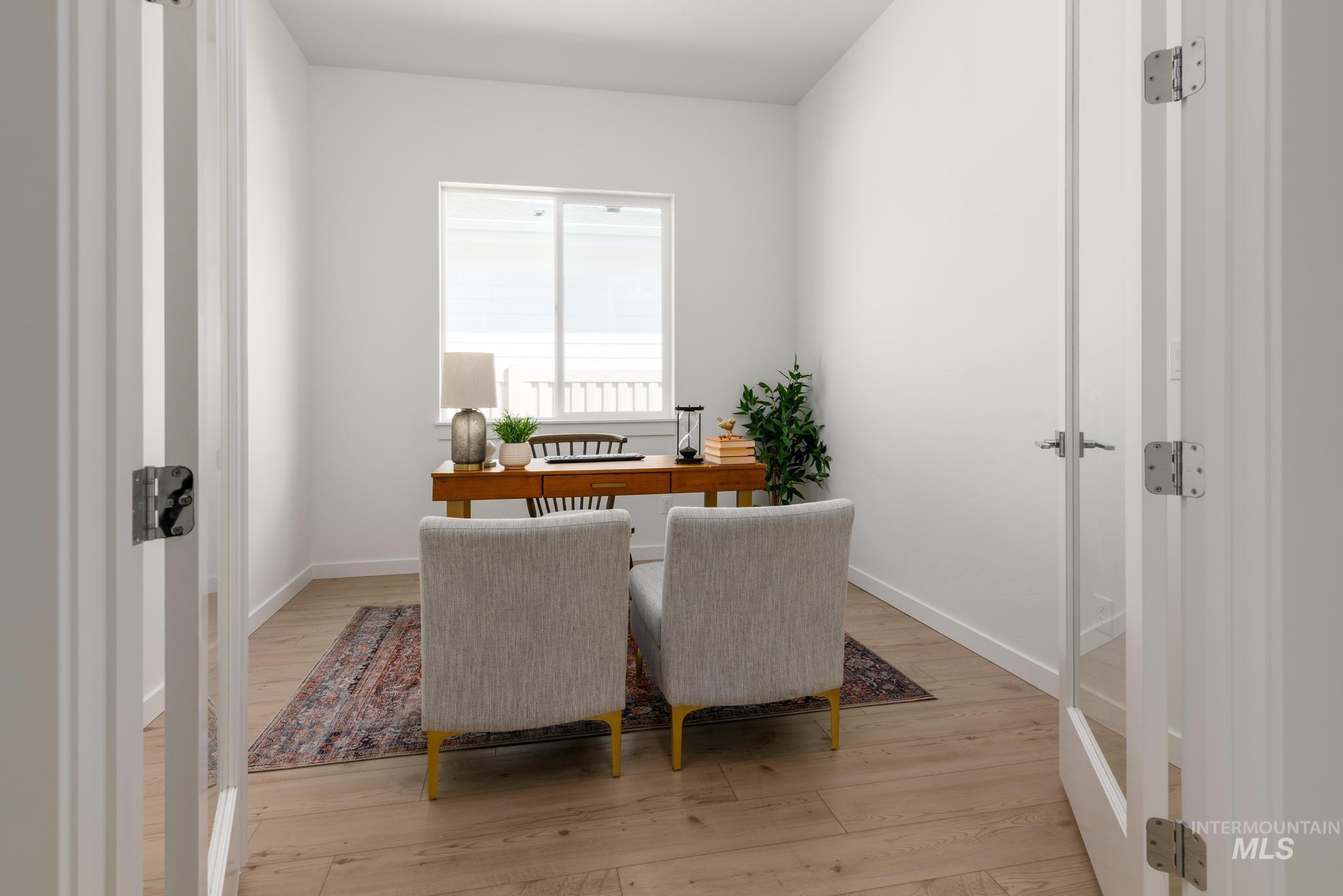 Home office featuring light wood finished floors and french doors