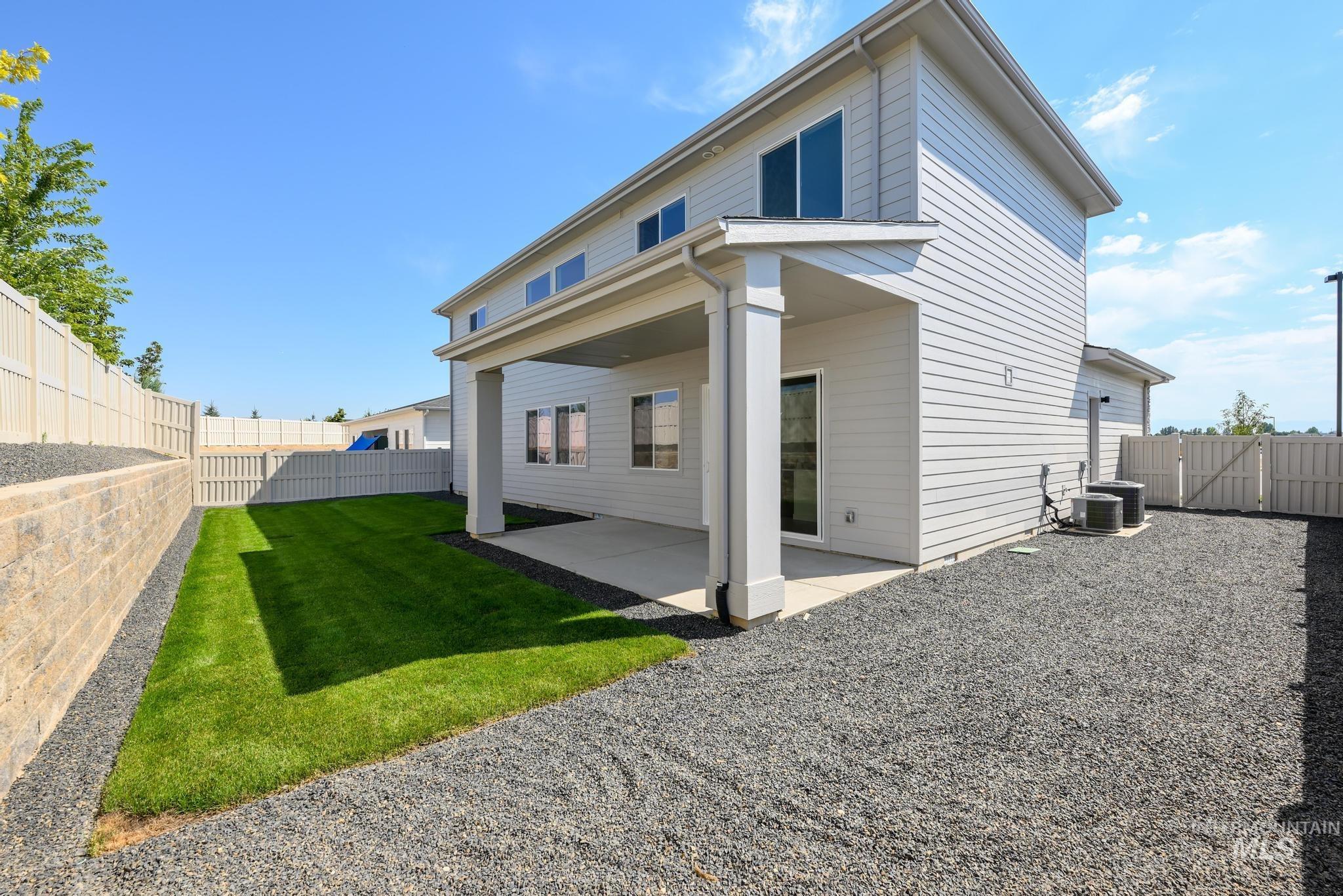 Rear view of property with a patio area, a fenced backyard, and a gate