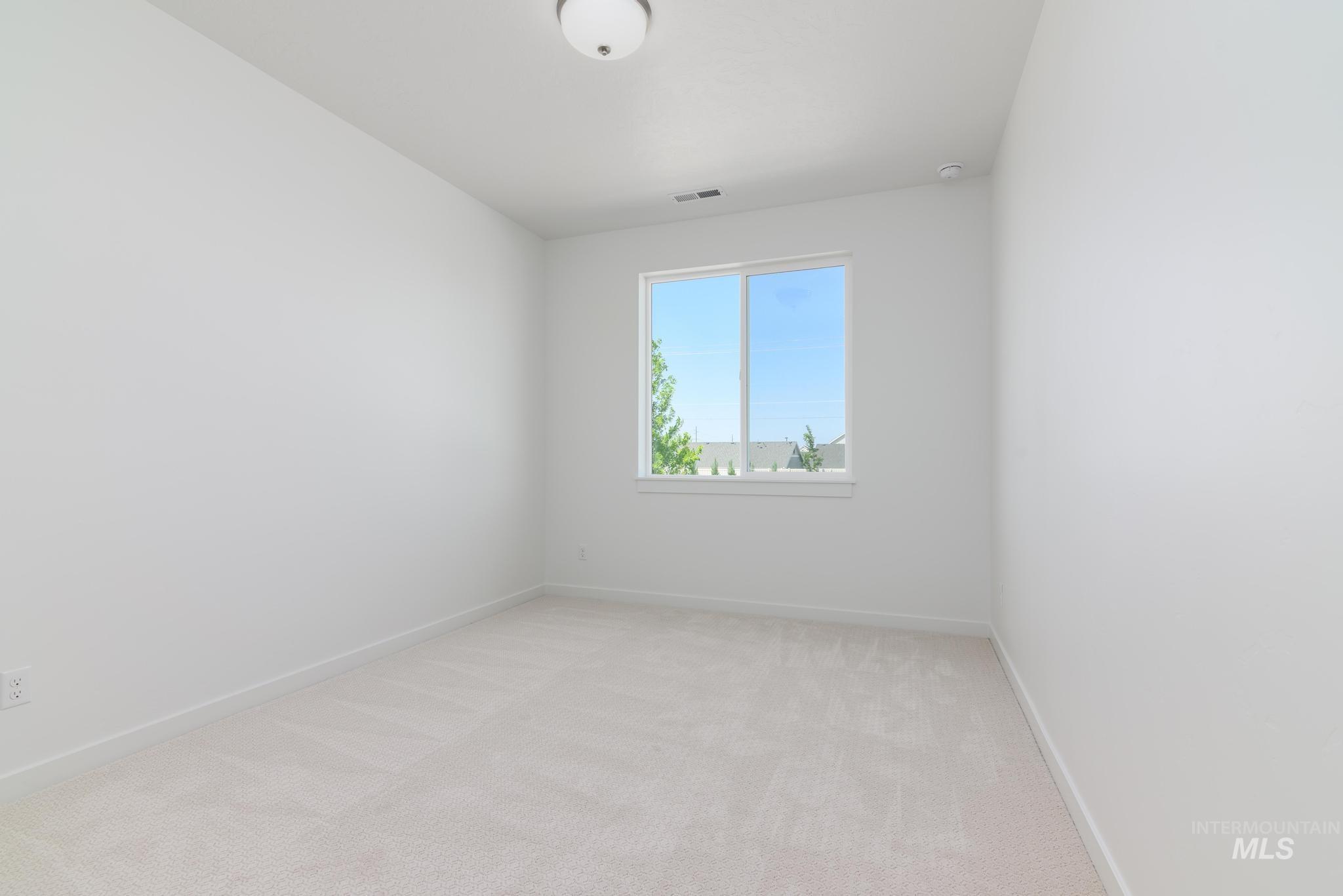 Unfurnished room featuring light colored carpet and baseboards