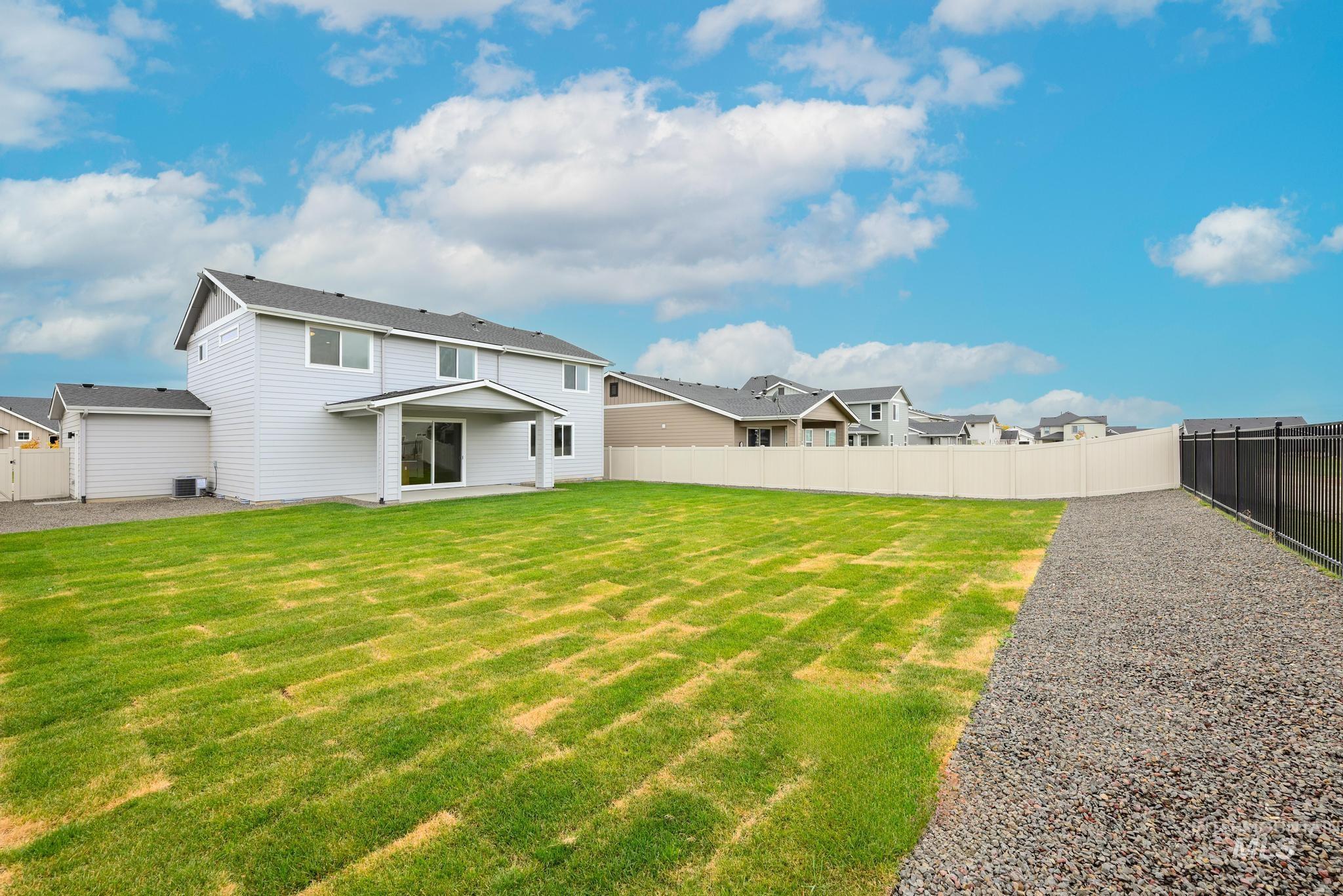 Rear view of house featuring a fenced backyard, a patio, and a residential view